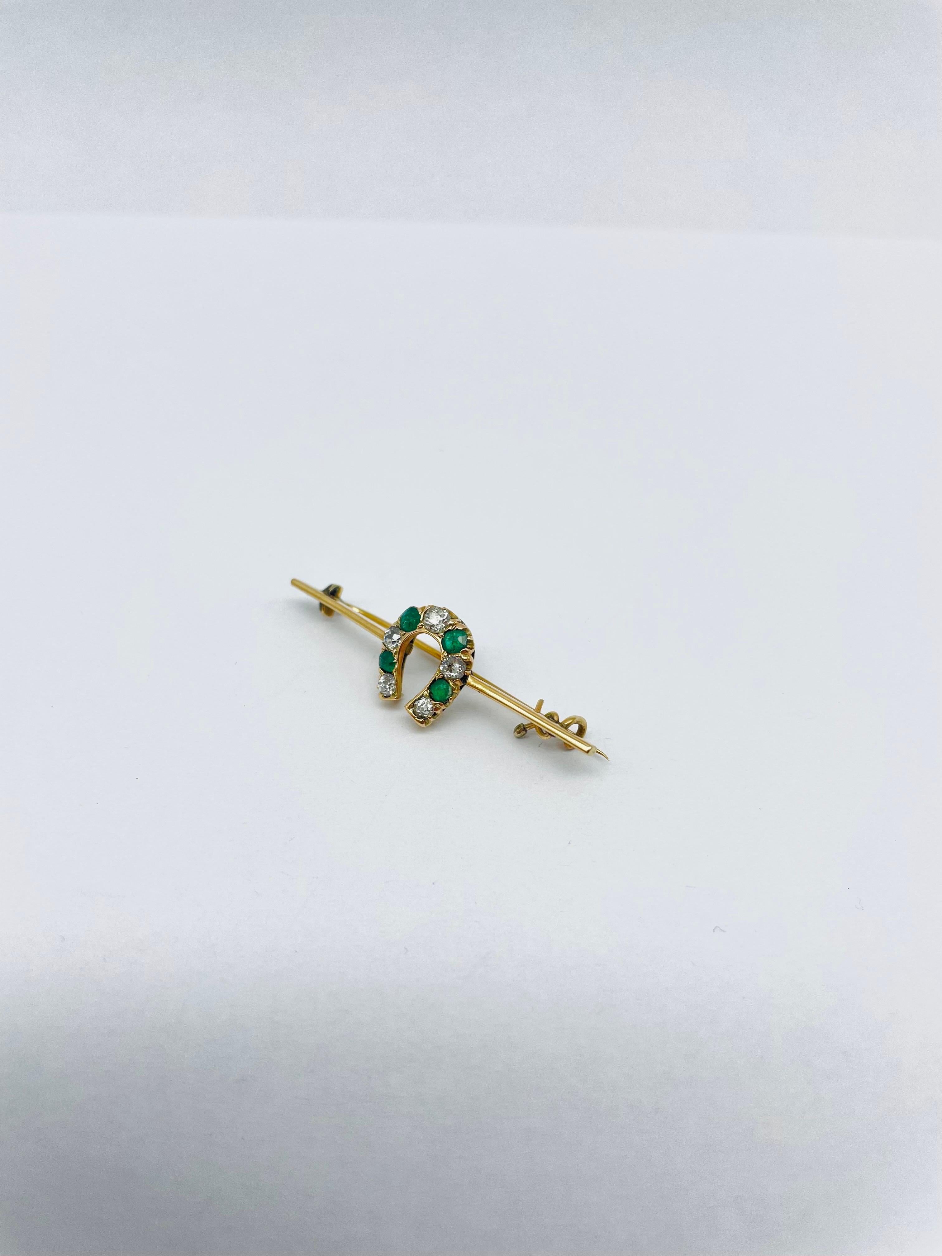 Horseshoe Bar Brooch with Diamonds and Emerald - a beautiful and elegant piece of jewelry that is sure to turn heads and capture attention. Crafted from 14k yellow gold with a finely worked design, this brooch is a true testament to the skill and