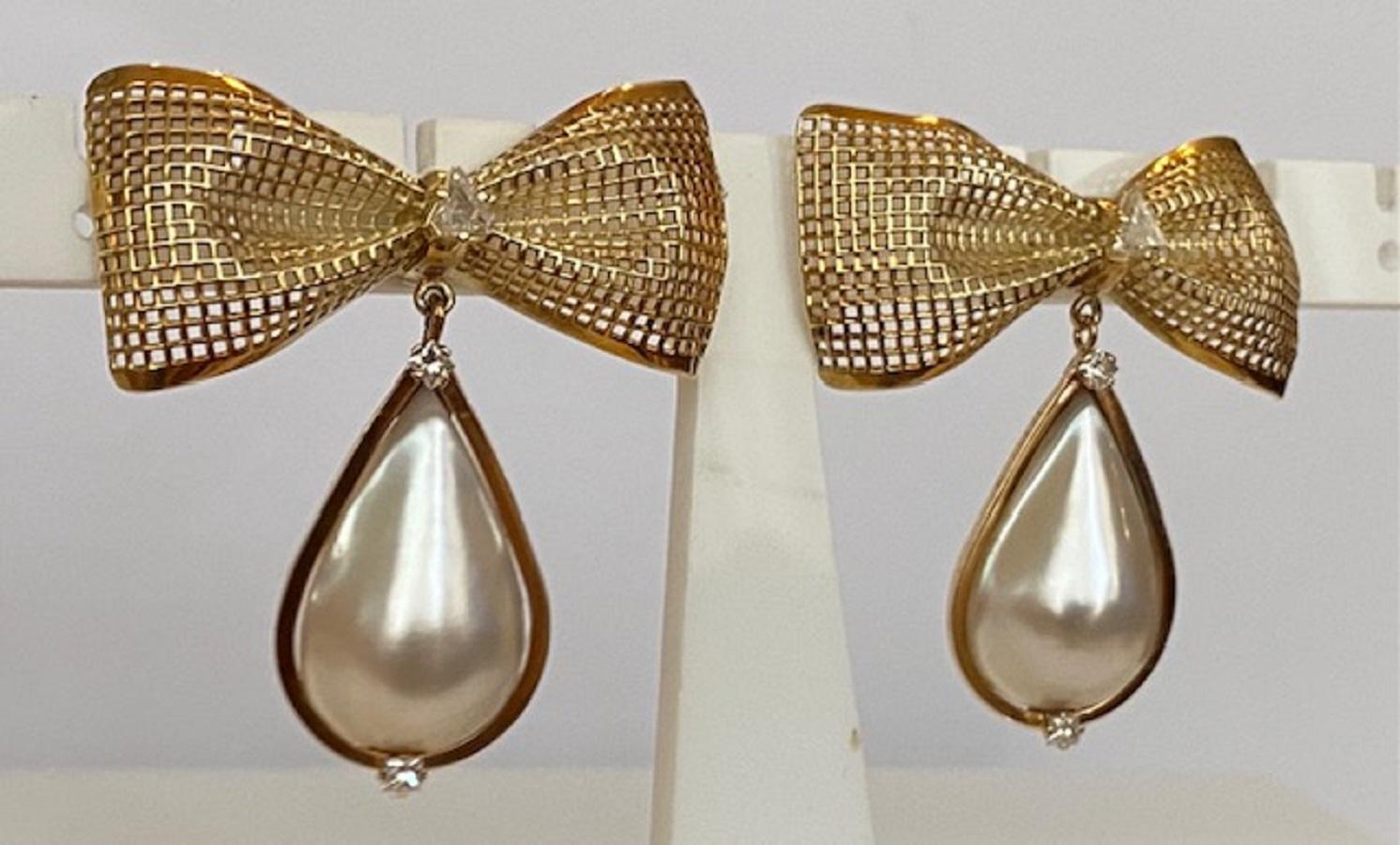 Offered in good condition, beautiful design ear studs in 14 kt yellow gold, with 2 cultured Mabe pearls, approx. 27 mm*16 mm, each decorated with 4 princess cut diamonds, approx. 0.32 ct in total, of quality H/VS and 2 triangle cut diamonds, approx.