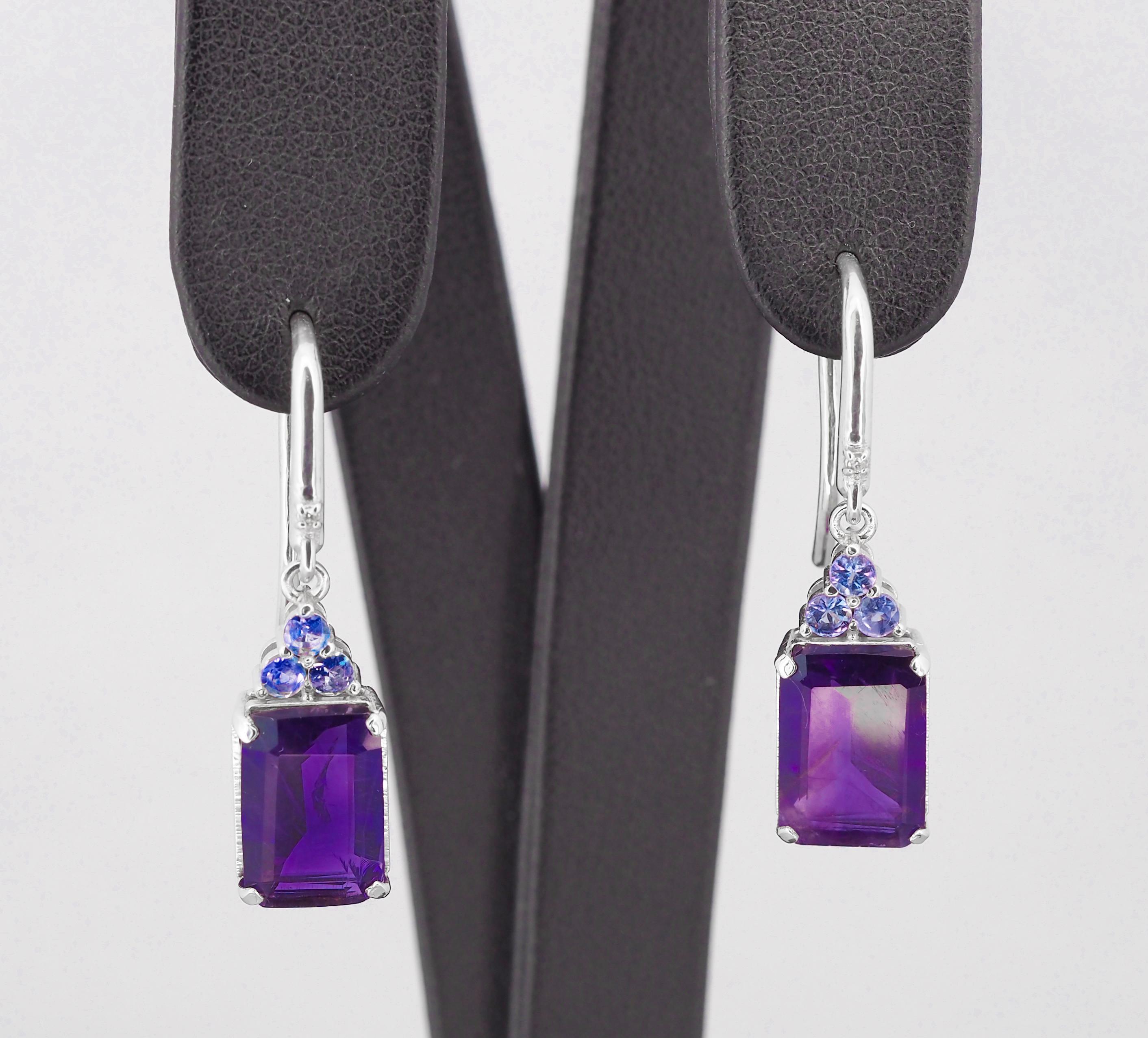 14 kt white solid gold earrings with central  natural amethysts, tanzanites and diamonds. Febrary birthstone.

Weight: 5.3 g.
Size: 33 x 8.5 mm.

Central sotnes: Natural amethysts, color - violet.
Weight: approx 6.00 ct in total, emerald