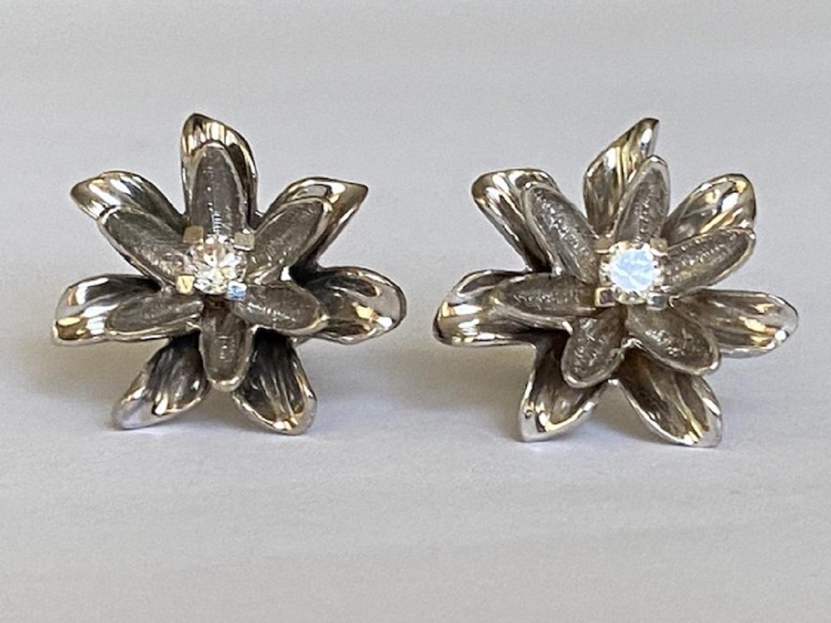 Offered in good condition, a pair of 14 kt white gold flower stud earrings set with 2 brilliant cut diamonds of approx. 0.15 ct in total, of quality H/VS.
Grade: 14 kt (marked 585)
2 brilliant cut diamonds: (0.075*2) approx. 0.15 ct in total,