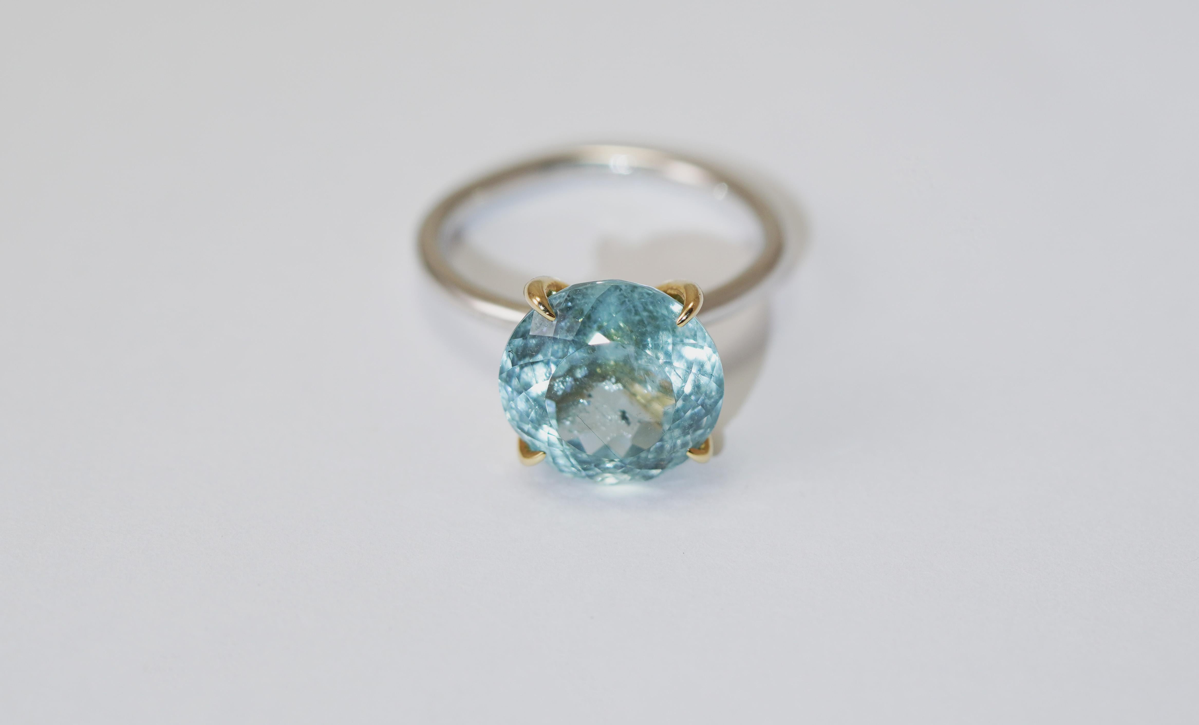 Cette élégante bague fabriquée à la main par Antonio Gems allie admirablement le raffinement moderne à l'art intemporel. Réalisé en or blanc et jaune 14 carats, ce modèle présente une fine tige en or blanc qui encadre délicatement une pièce