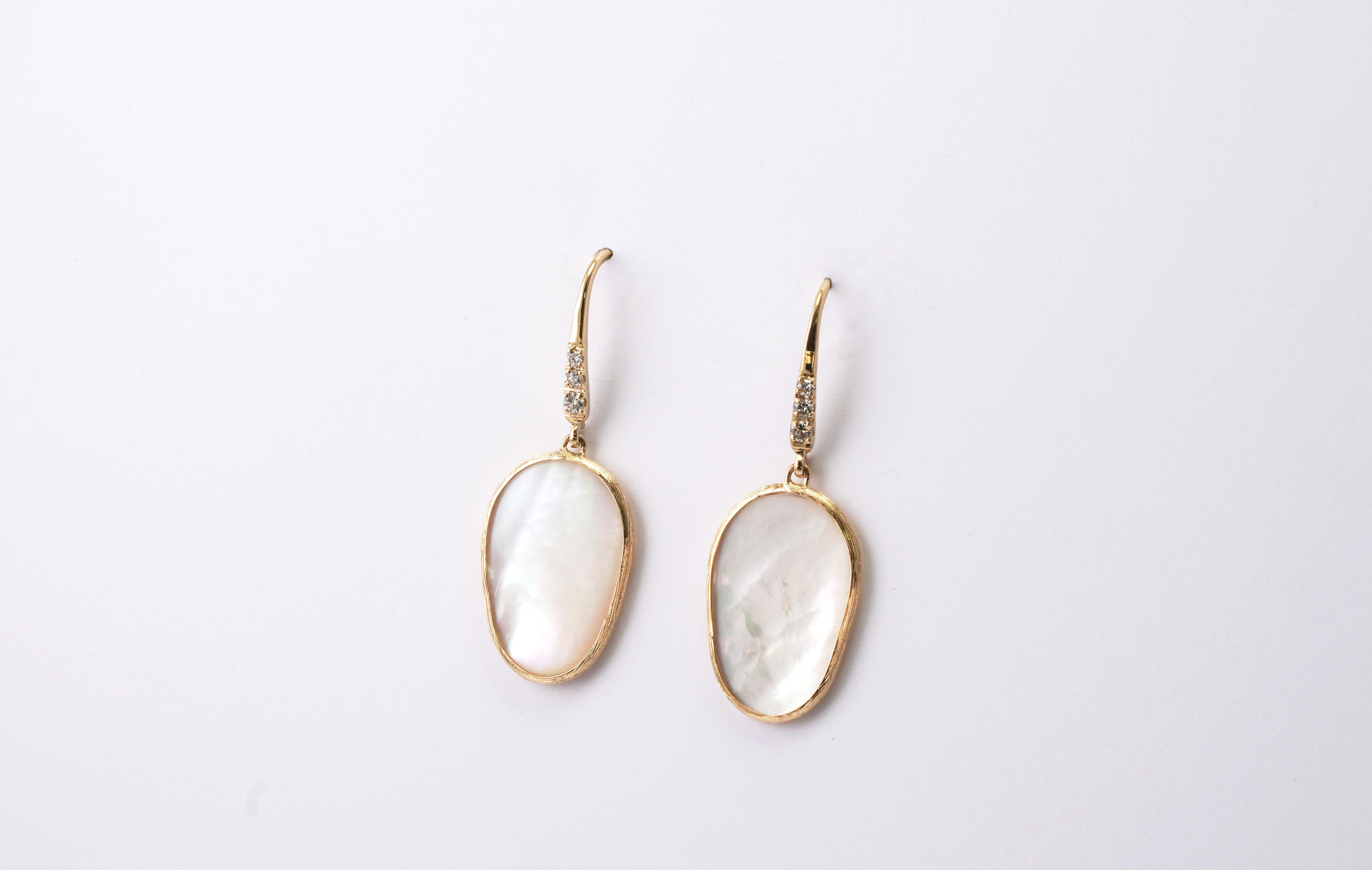 14 kt Gold pair of earrings with Mother of Pearl and Diamonds
Gold color: Yellow
Dimensions: 38 mm height
Total weight: 3.40 grams

Set with:
- Mother of Pearl ( Nacre )
Cut: Cabochon
Color: White

- Diamonds (6 pieces)
Cut: Brilliant
Weight: 0.08