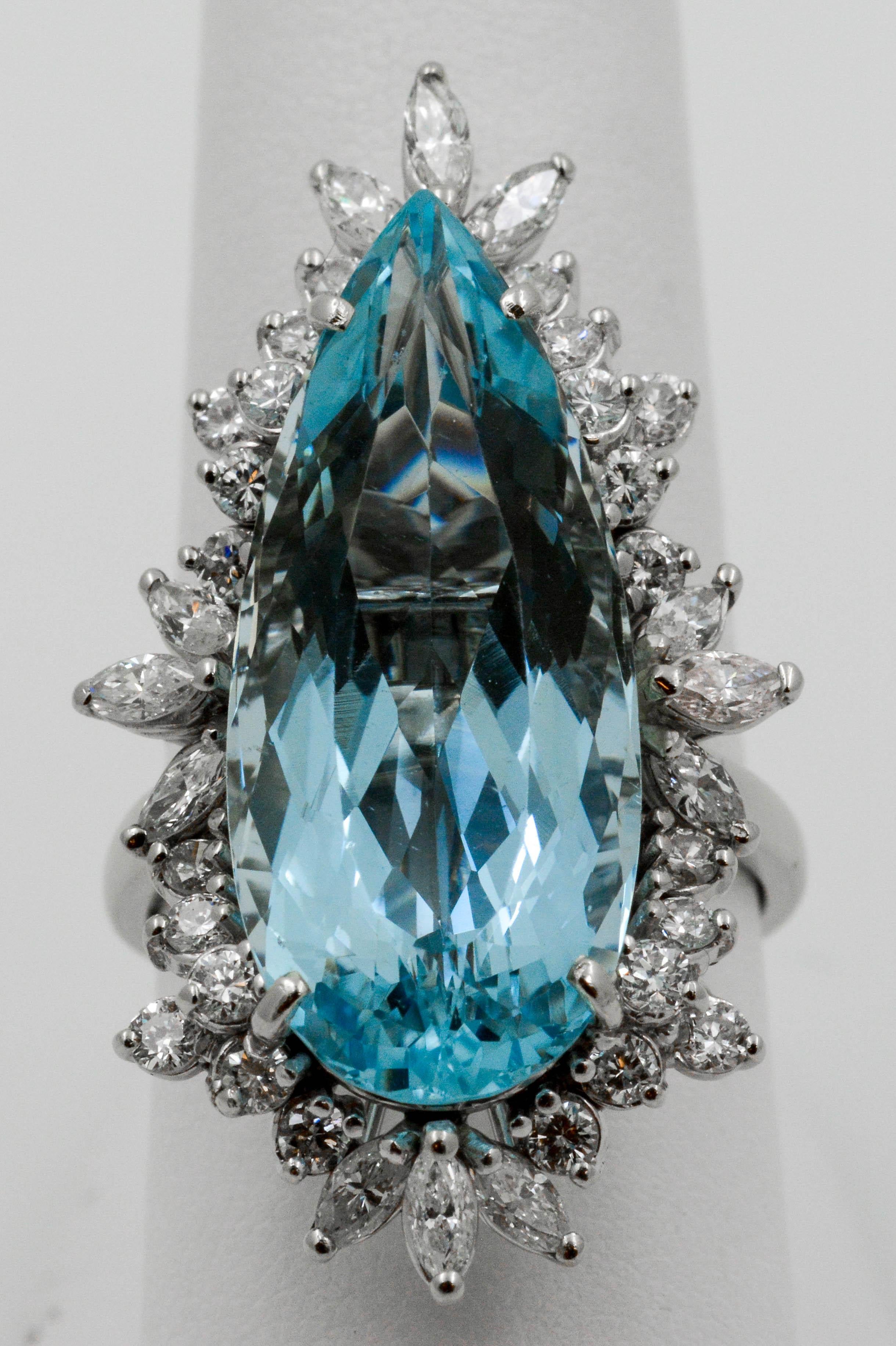 Circa 1970s mid-century modern 14 Karat white gold ring set with one pear shape Aquamarine 16.80 carat total weight (27.9 mm x 12.15 mm) surrounded with 12 marquis cut diamonds .60 carat total weight, and 24 round brilliant cut diamonds .72 carat