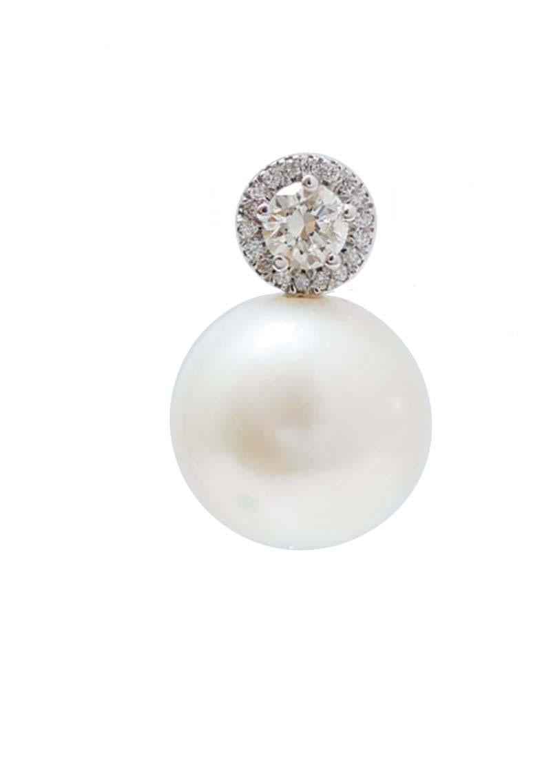 Elegant earrings in 14 kt white gold structure mounted with a bigger central diamond surrounded by diamonds. As pendant, a pearl.
These earrings were totally handmade by Italian master goldsmiths and they are in perfect conditions.
Diamonds 0.18