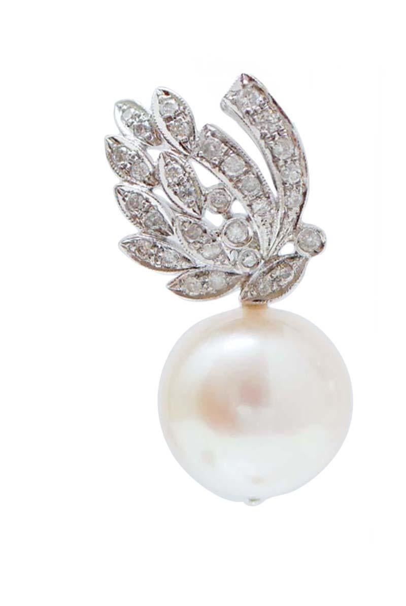 Belles boucles d'oreilles pendantes en structure de platine montées avec des feuilles serties de diamants et, en pendentif, une perle.
Ces boucles d'oreilles ont été entièrement réalisées à la main par des maîtres orfèvres italiens et elles sont en