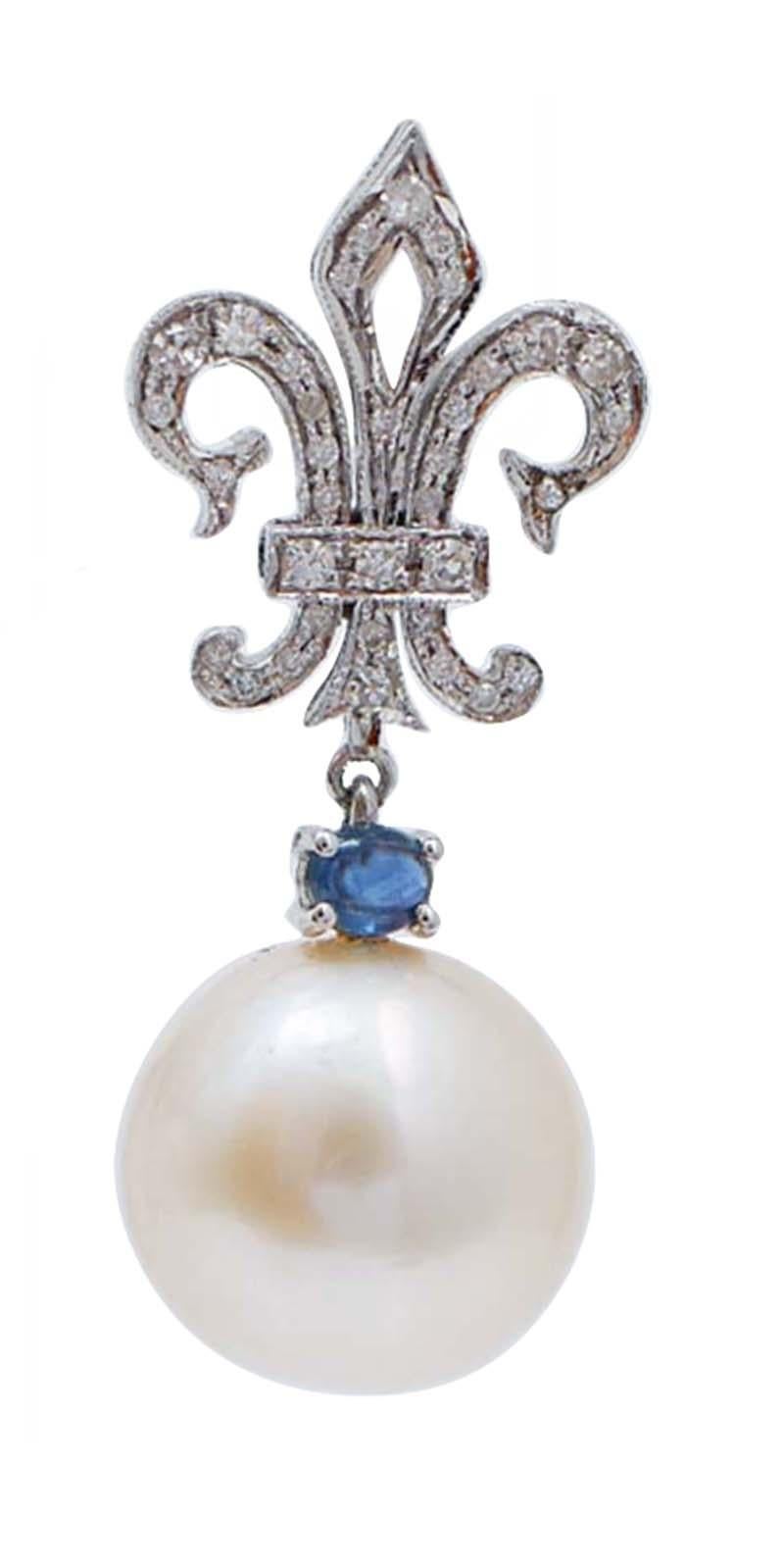Dangle earrings in 14 kt white gold structure mounted with a structure in the upper part studded with diamonds and a sapphire and, as pendant, a pearl.
These earrings were totally handmade by Italian master goldsmiths and they are in perfect