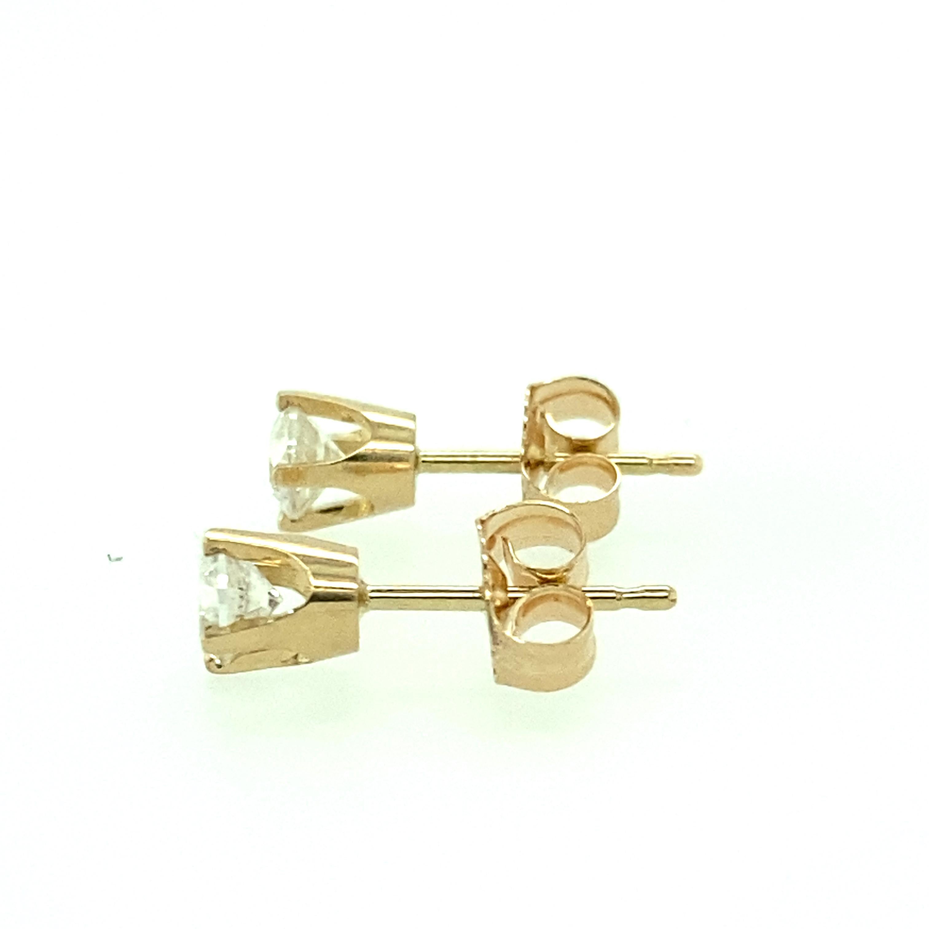 One pair of estate 14 karat yellow gold (stamped 585 14K) diamond stud earrings, each set with one round brilliant diamond, approximately 0.35 carat total weight with matching H/I color and I1 clarity.  The each diamond measures 3.73mm and are