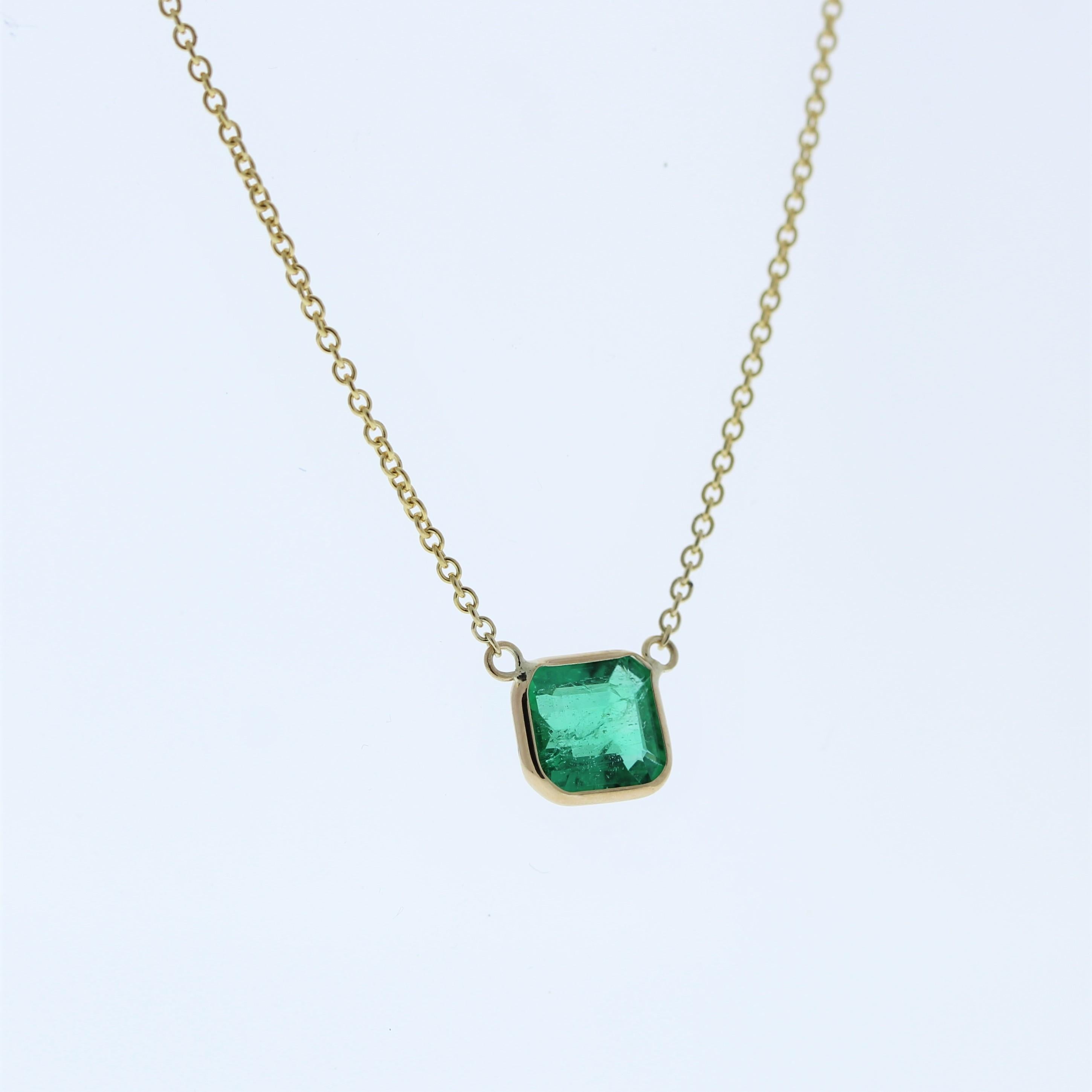 The necklace features a 1.40-carat Asscher-cut emerald set in a 14 karat yellow gold pendant or setting. The Asscher cut and the rich green color of the emerald against the yellow gold setting are likely to create an elegant and eye-catching fashion