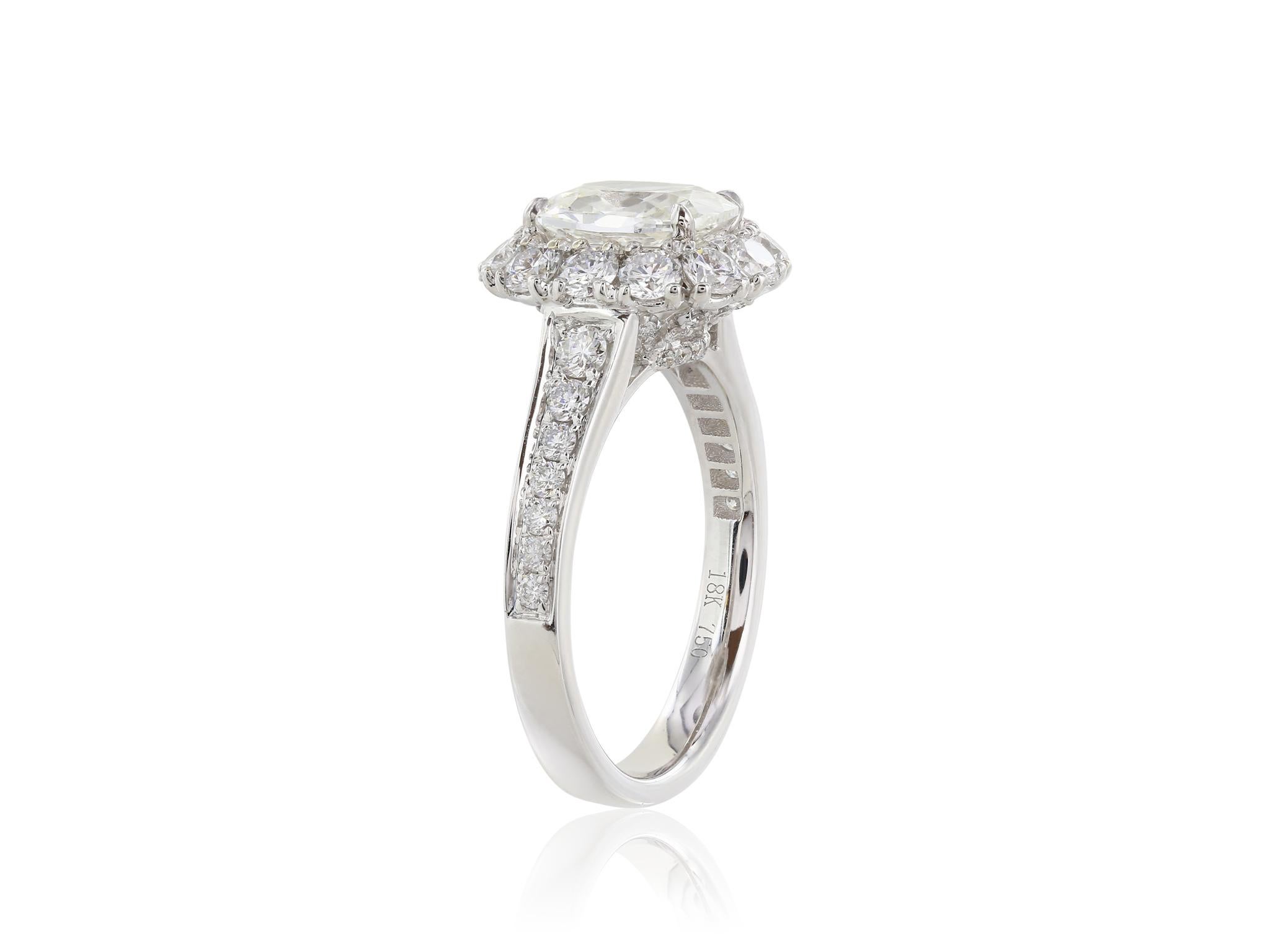 18 karat white gold ring consisting of 1 cushion cut diamond weighing 1.40 carats with a color and clarity of G/VS1 respectively set in a halo setting with round brilliant diamonds weighing 1.14 carats.