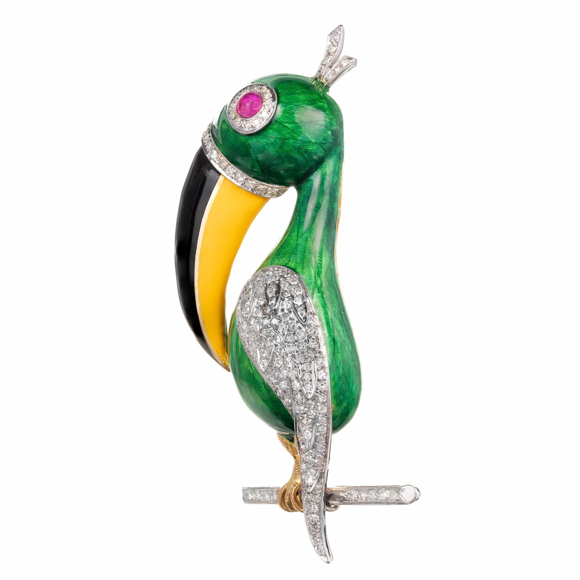 18k yellow and white gold toucan design toucan brooch.  A green enameled toucan with a black and yellow enamel beak is adorned with black with a diamond studded feather down its side, a diamond tuft of feathers at the top, Diamond circle around a