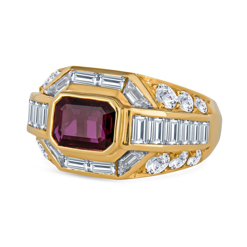 This beautiful ring features a 1.40 Carat Emerald Cut Thai Ruby bezel set in 18 Karat yellow gold. It is accented with a stepped halo of natural baguette and trapezoid diamonds. It is also surrounded by graduating round diamonds and channel set