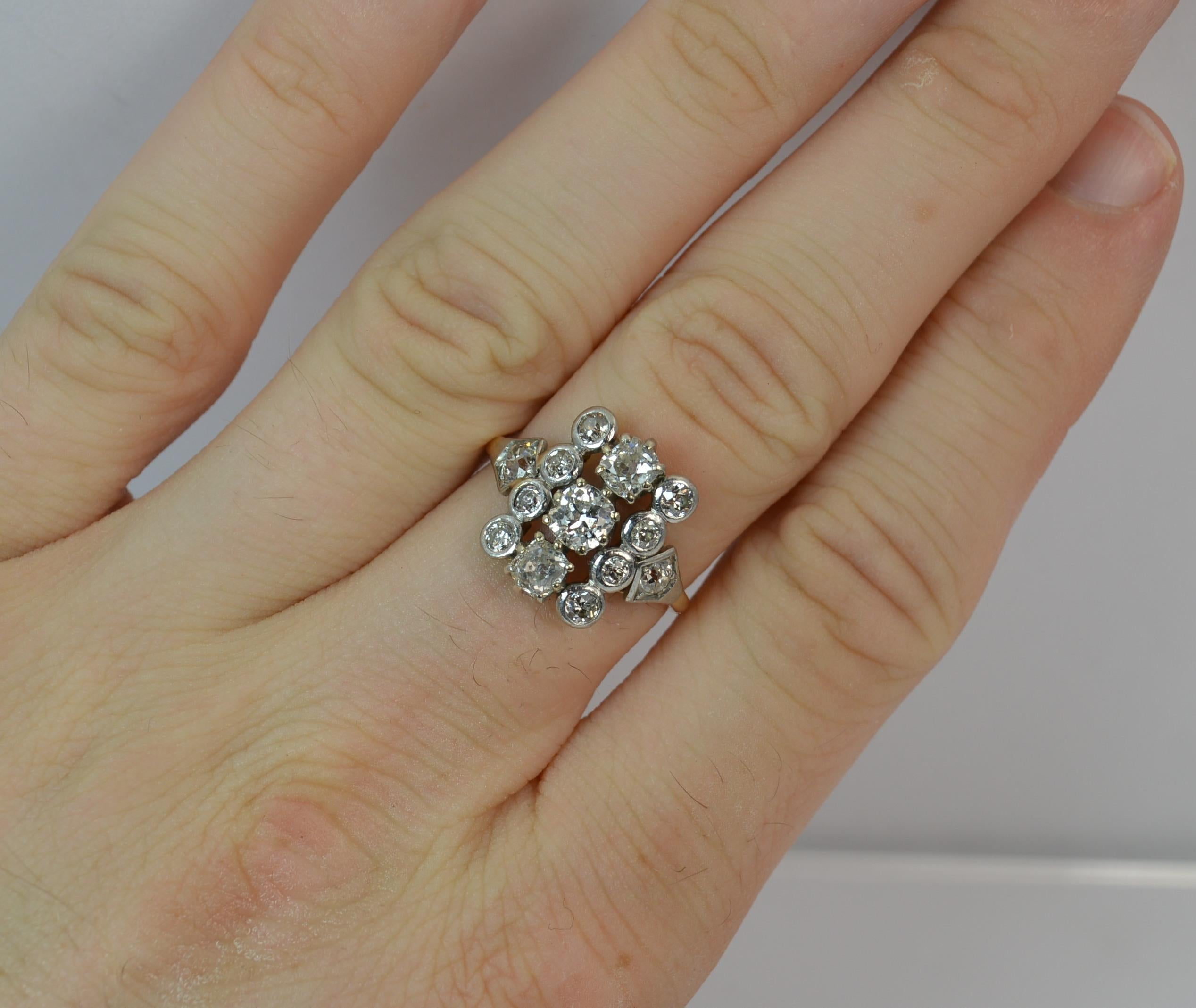 
A true antique diamond cluster ring of Edwardian period. 

Modelled in solid 18 carat gold with a platinum head.

Set with three large old cut diamonds in claw settings as a central column with four smaller diamonds in collet mounts to each side