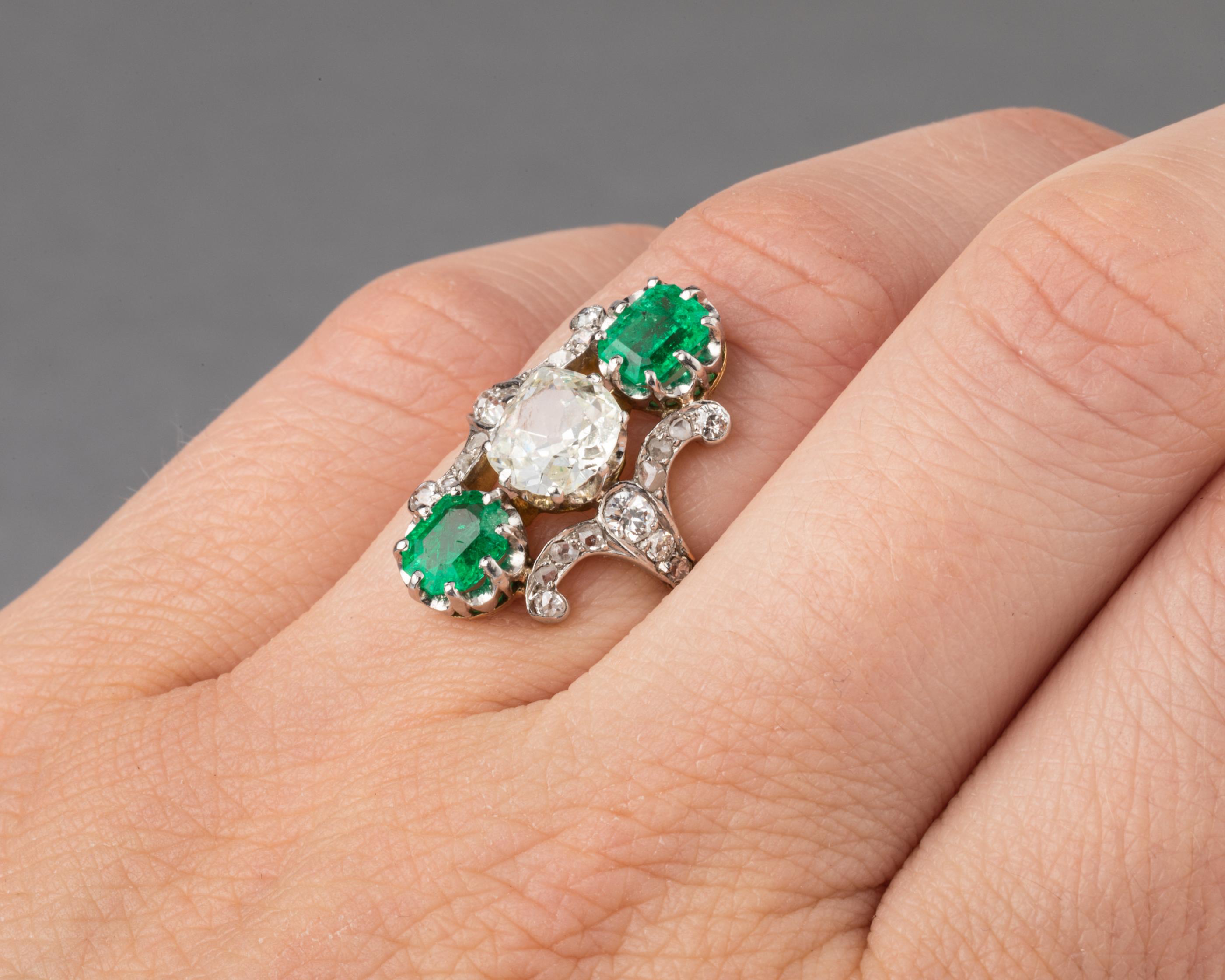 Very beautiful antique ring, made in France circa 1900.

The ring is yellow gold 18k, eagle head mark.
The central diamond weights 1.10 carats estimate. The color is K/L estimate and SI1 clarity.
The two emeralds weights 0.70 carats each