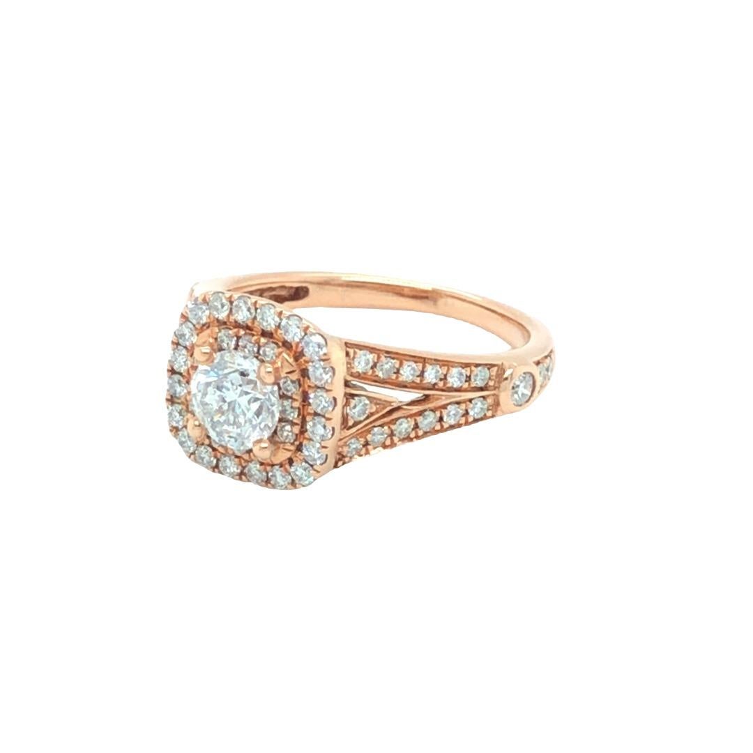 Classically beautiful, this modern engagement ring features a round brilliant cut diamond center weighing .60 carat, smartly encircled by cushion shaped double halos. The detail on the under gallery and ring band is stunning. Total diamond weight of