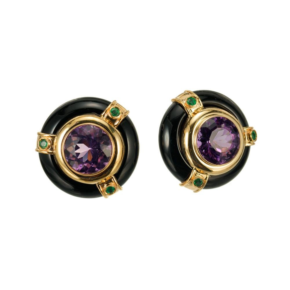 Round black onyx and amethyst clip post earrings. 14.00cts Amethysts accented with 6 green emeralds set in 14k yellow gold. Signed MB.

2 round purple amethyst, approx.  14.00cts
2 round black onyx open discs 
6 round green emeralds, approx.