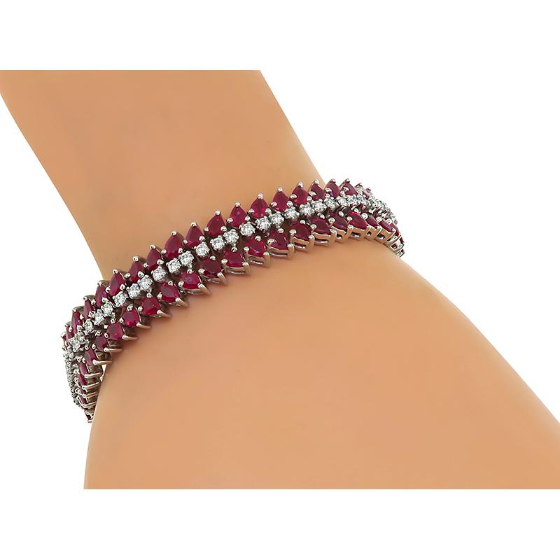 This is a charming 18k white gold bracelet. The bracelet is set with lovely pear shape rubies that weigh approximately 14.00ct. The rubies are accentuated by sparkling round cut diamonds that weigh approximately 1.40ct. The color of these diamonds