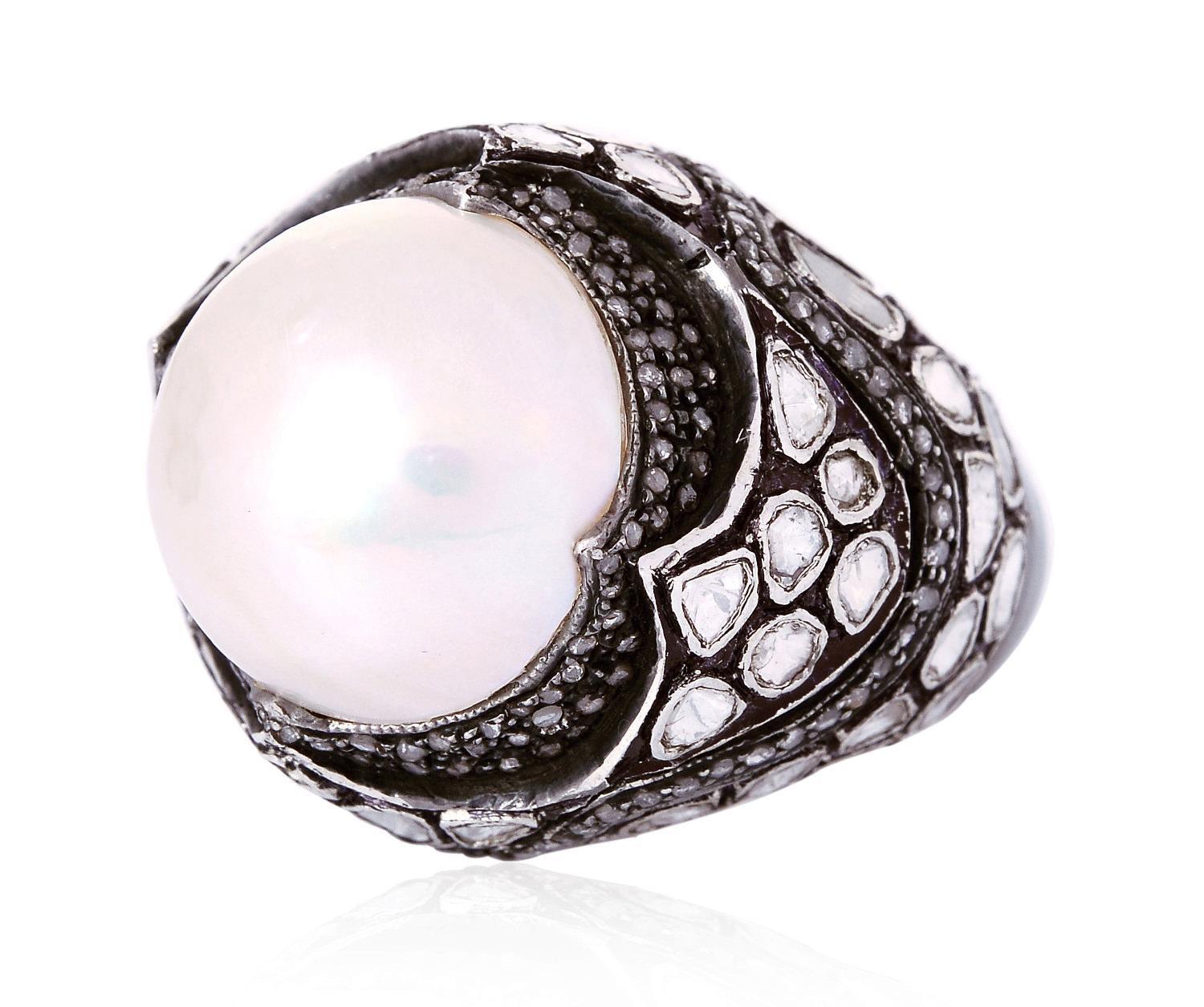 This ring has been meticulously crafted from 18-karat gold, sterling silver with blackened finish. Handcrafted in 14.07 carat pearl & illuminated with 2.68 carats rose cut diamonds. 

The ring is a size 7 and may be resized to larger or smaller upon