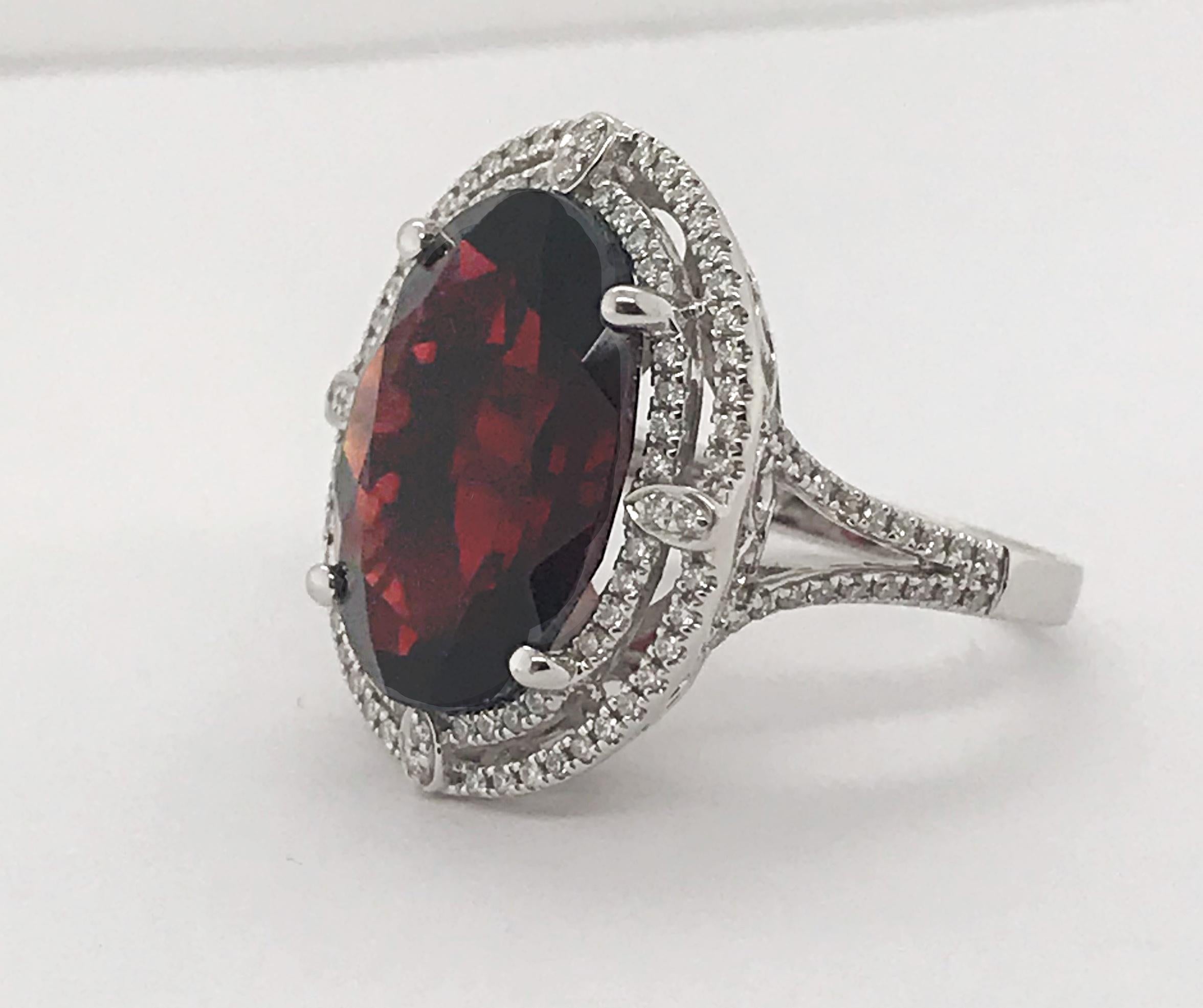Beautiful oval cut Garnet that is 14.08ct's and set in 14kt white gold. The ring feature 1.20 carats of round brilliant cut diamonds. 

Garnet = approximately 14.08 carats 
124 diamond = approximately 1.20 carats total weight. 
Set in 14 karat white