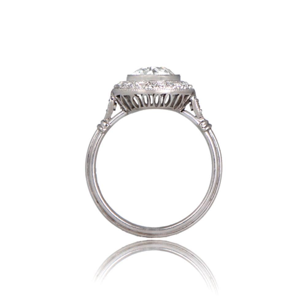 This vintage diamond ring showcases a lively old European cut center diamond weighing approximately 1.40 carats, J color, and VS2 clarity. The diamond is surrounded by a row of pave-set old mine cut diamonds accented with fine milgrain, with