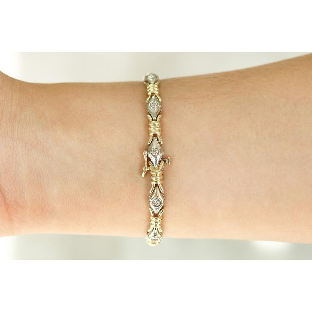 Showcased is a fancy link diamond bracelet in 14K two-toned gold. This bracelet features a unique golden link embellished by white diamonds. Both links have a high-polished finish and make for a gorgeous statement piece. The 10 point diamonds are