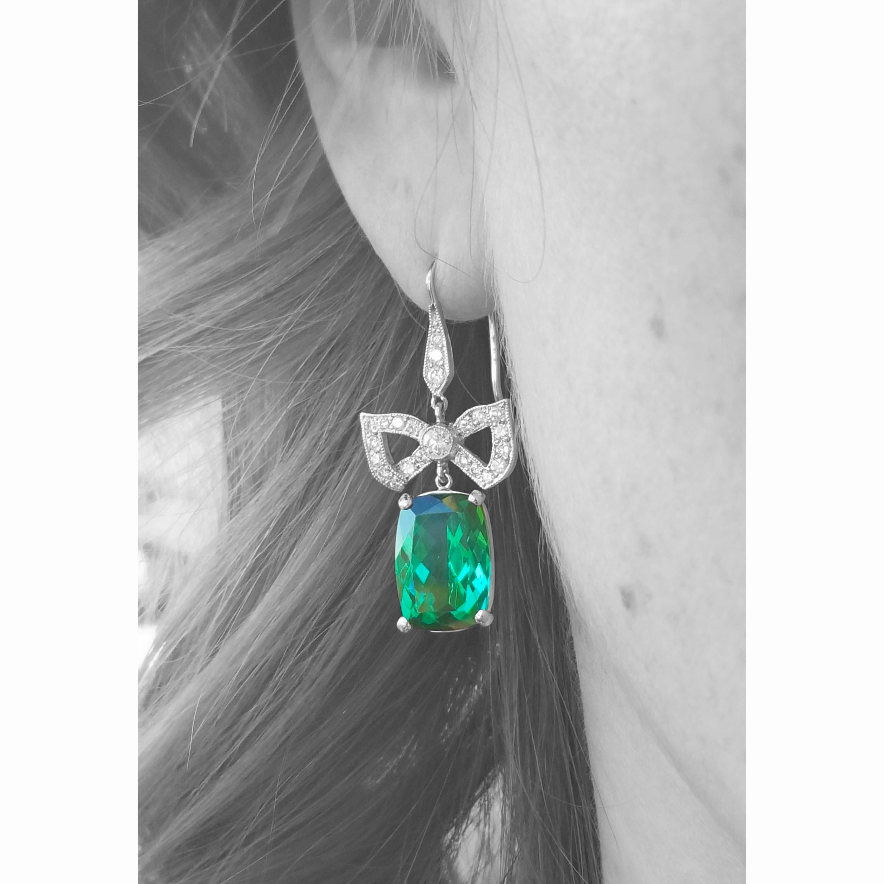 This pair of exquisitely cut and perfectly matched green tourmaline are stunning in these graceful platinum and white 18kt diamond earrings. A nod to old European design, the classic bow earrings are updated with modern cut tourmalines and