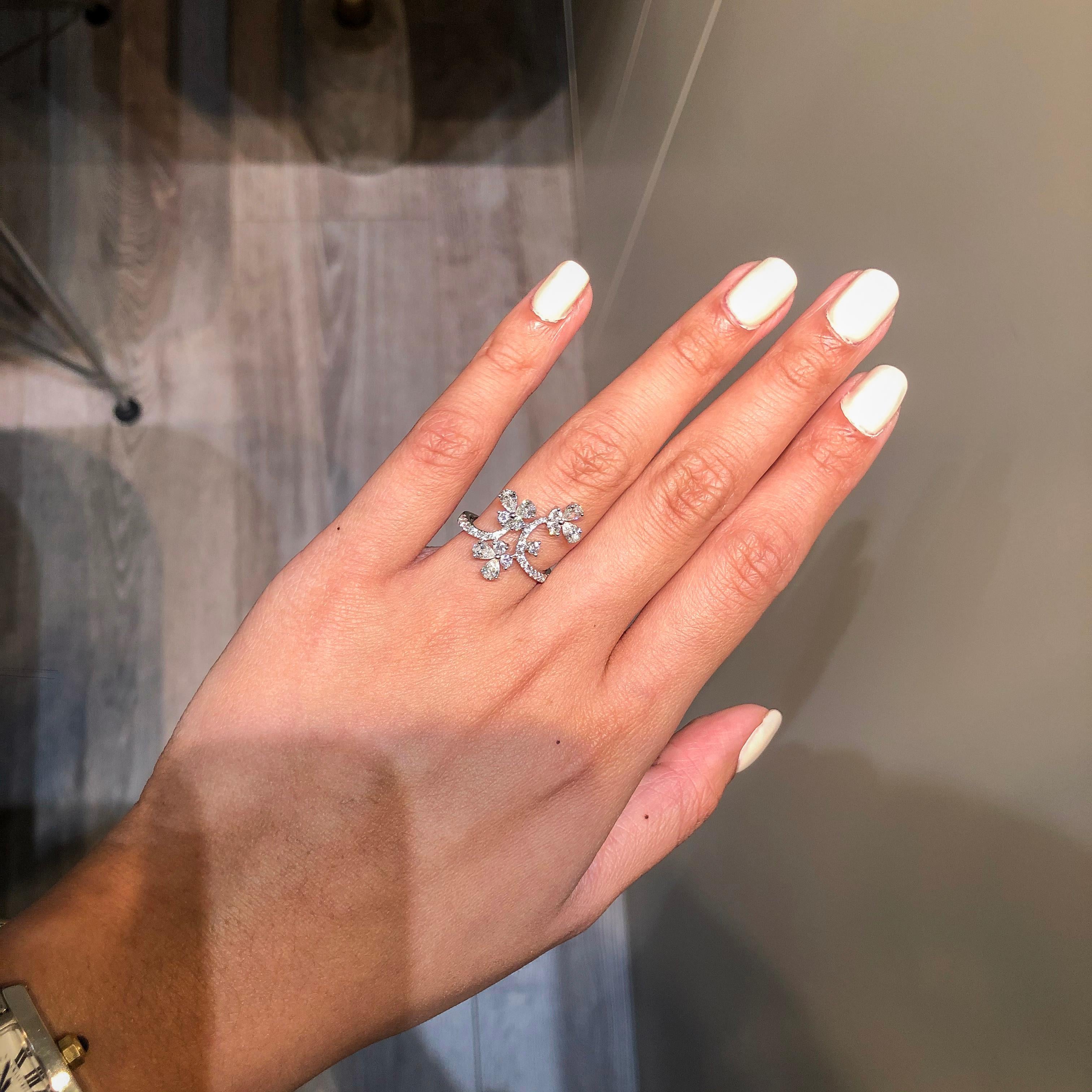 This is an incredibly gorgeous ring featuring three fluttering butterflies in an accented 18k white gold mounting. Each butterfly is set with 2 pear shaped diamonds and 2 round diamonds. Tapered shank accented with more sparkling round diamonds.
