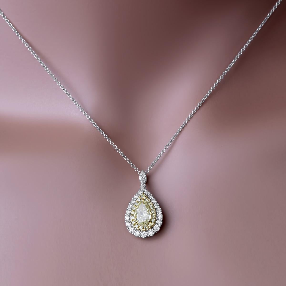 This pendant showcases a  0.70 carat pear-shaped yellow center, encircled by a halo of round yellow diamonds, creating the illusion of a more substantial centerpiece. It is further surrounded by an additional halo of round white diamonds, lending it