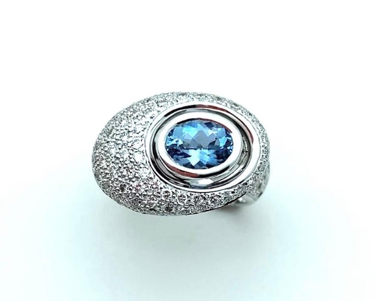 This modern Salvador Dali-esque ring is unusual and chic, featuring a vivid blue, gem-quality aquamarine and pave set round brilliant diamonds! The aquamarine is from the Santa Maria Mine in Brazil, renowned as the source of exceptionally fine,