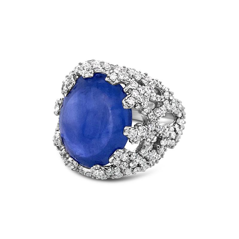 This cocktail ring features a 14.10 carat heated blue double Cabochon sapphire surrounded by 1.46 carat total weight of diamonds in a coral reef pattern. It is set in 18 karat white gold. This ring is a size 5 but can be resized upon request.