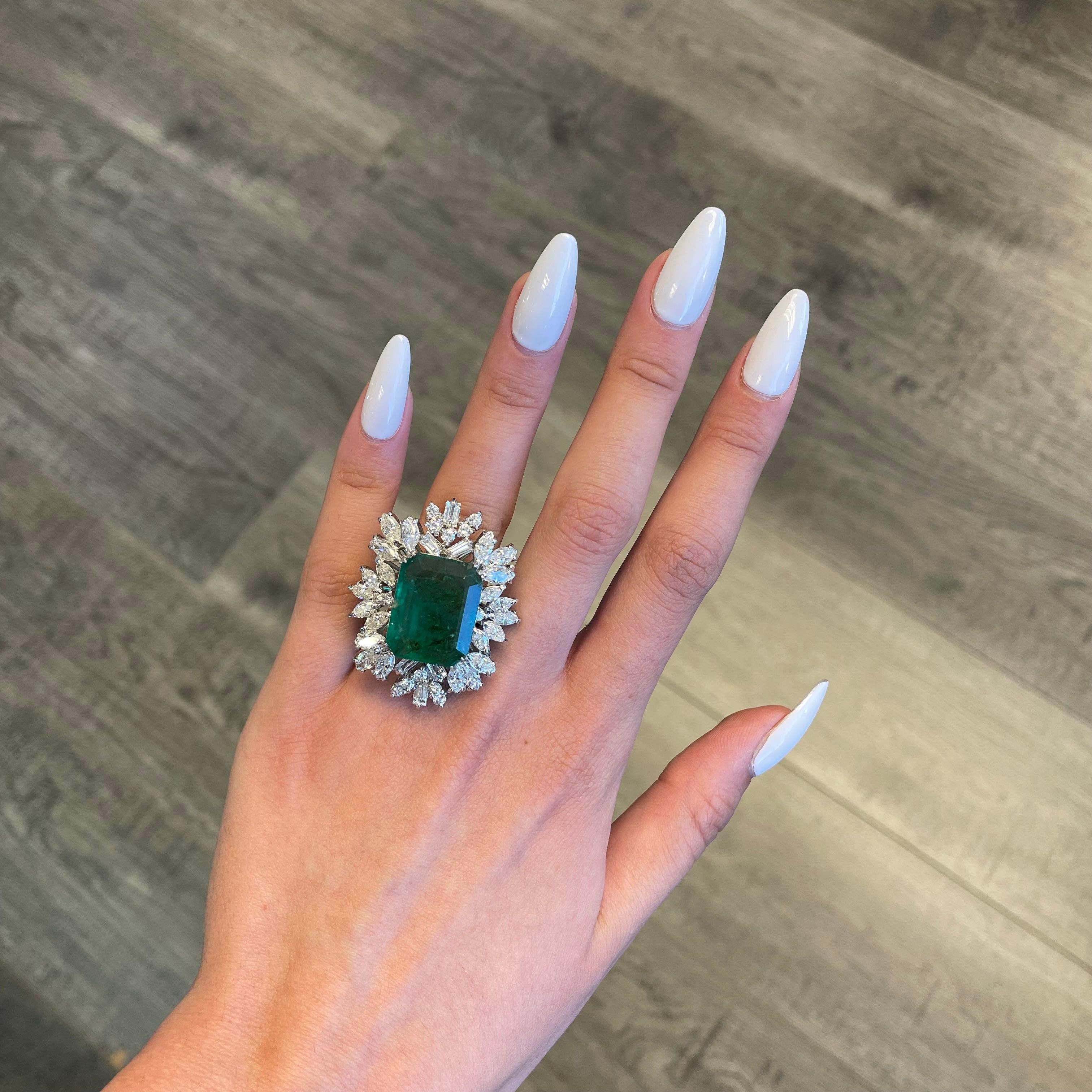 Vintage emerald with diamonds ring, circa 1970's.  
Approximately 14.10ct emerald apx F2 surrounded by apx 5.35ct of round, marquise, and baguette diamonds. Apx 19.45ct total gemstone weight, set in 18k white gold. 
Accommodated with an up to date
