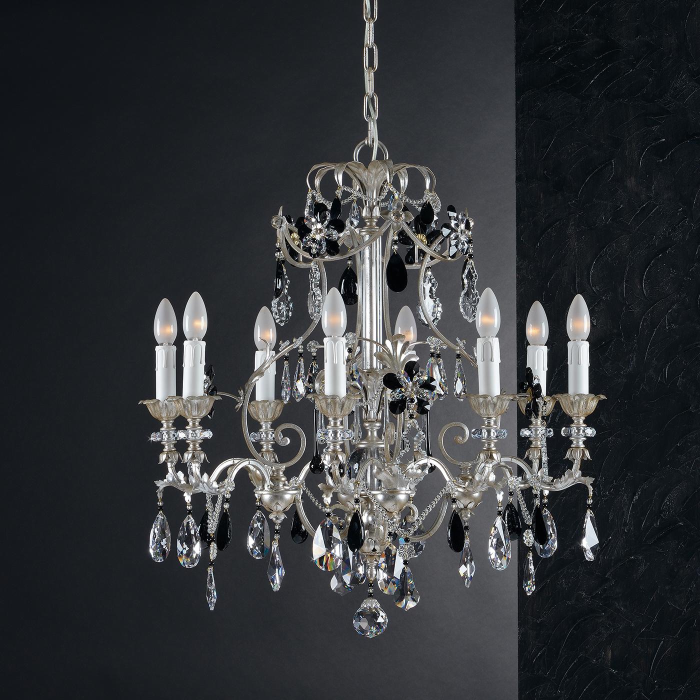 A traditional chandelier gets a modern makeover in the 1412 Chandelier. Featuring a glistening silver leaf finish, the chandelier has eight arms, each with a candle-inspired light. Topping the chandelier off are multifaceted crystals, alternating in