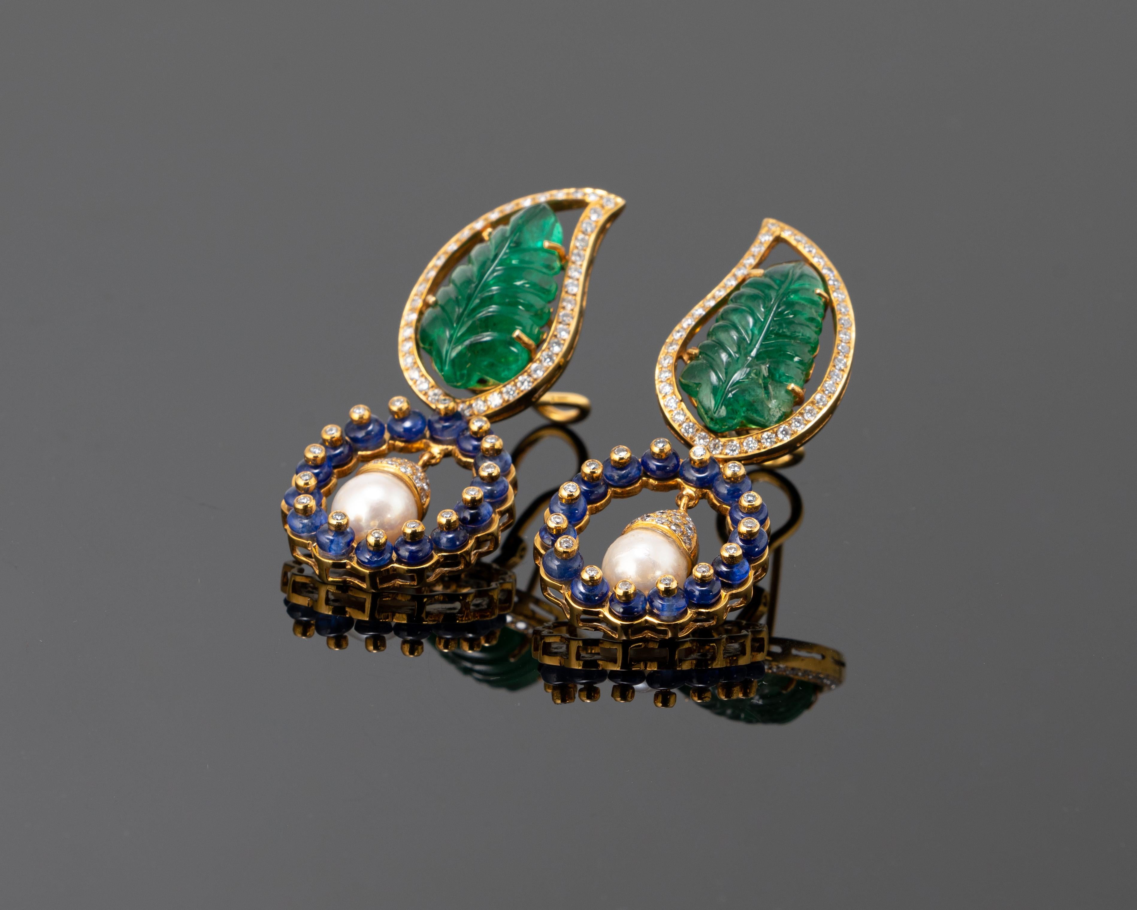 A gorgeous pair of art-deco, carved Zambian Emerald leaves dangling earrings, with Sapphire and South Sea Pearls set in solid 18K Yellow Gold. The earrings are around 1.5inches long, and have an omega and push-pull backing, making it more secure to