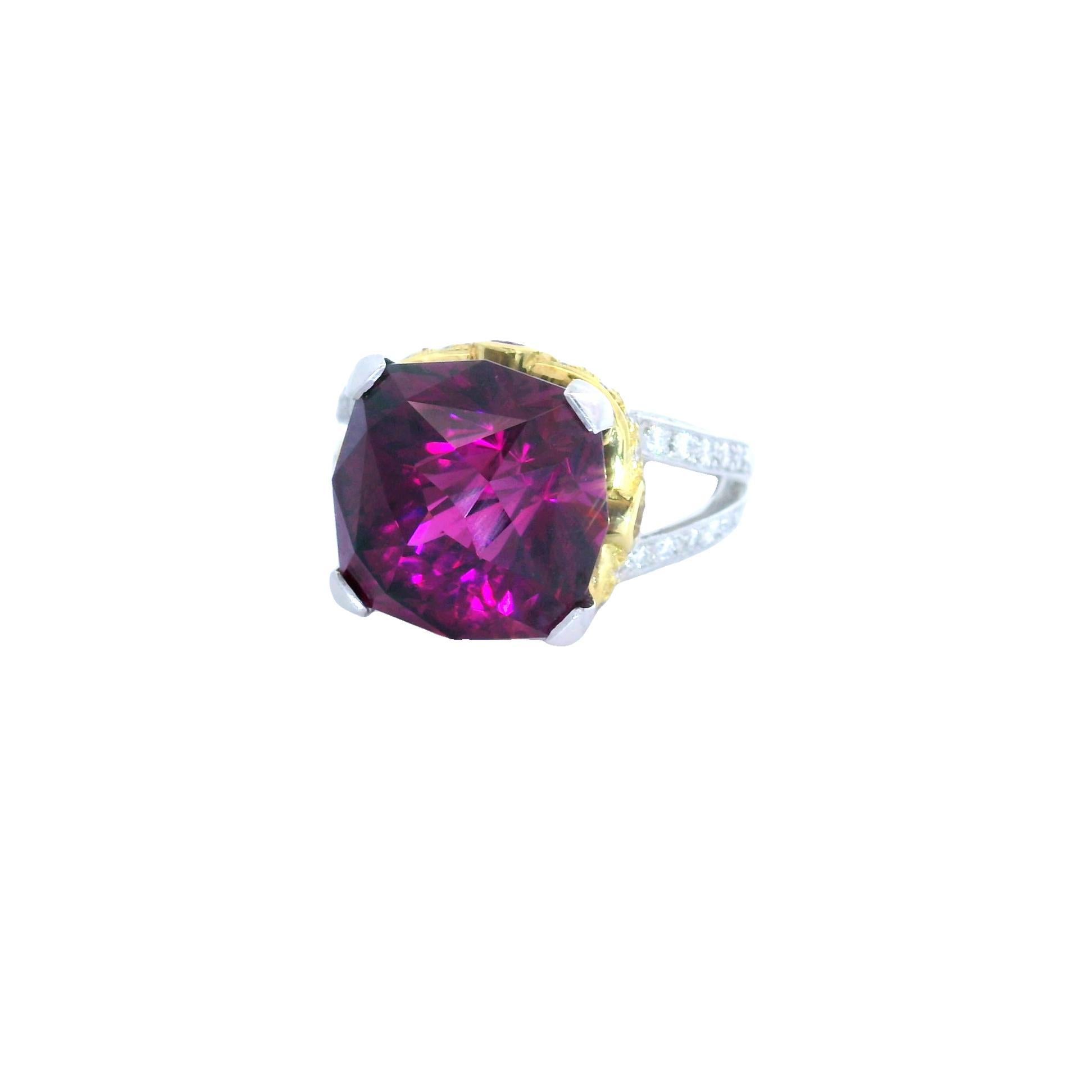 A captivating ring showcasing a magnificent 14.18-carat rhodolite garnet, expertly cut in a unique rose shape. The garnet's deep and vibrant royal purple color has a hint of red that takes the stone over the top. It is complemented by the brilliance