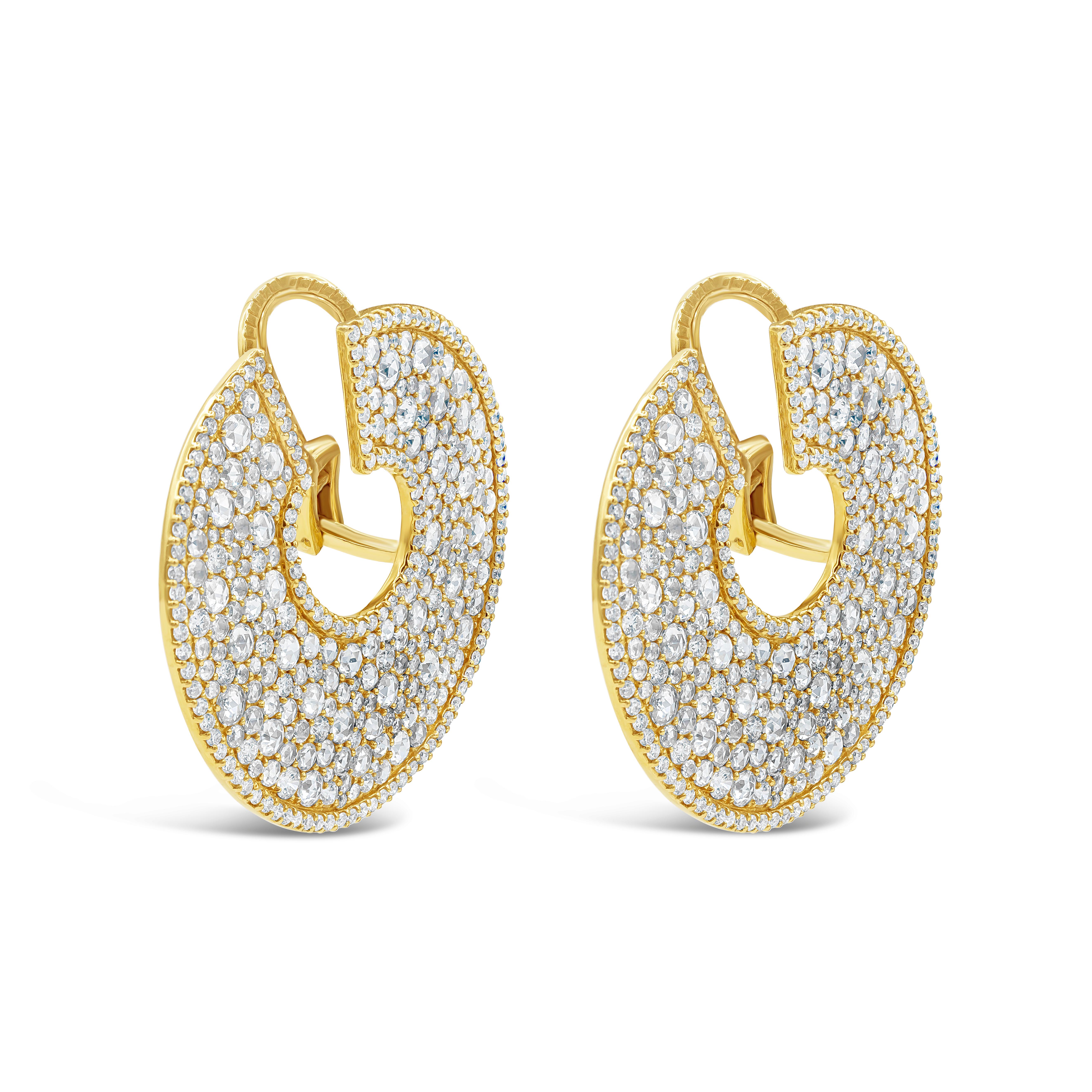 A unique and important pair of earrings showcasing 9.62 carats total of rose cut diamonds set in chic circular design, accented with round brilliant diamonds. Edged with more round diamonds in a polished 18K yellow gold mounting. Accent diamonds