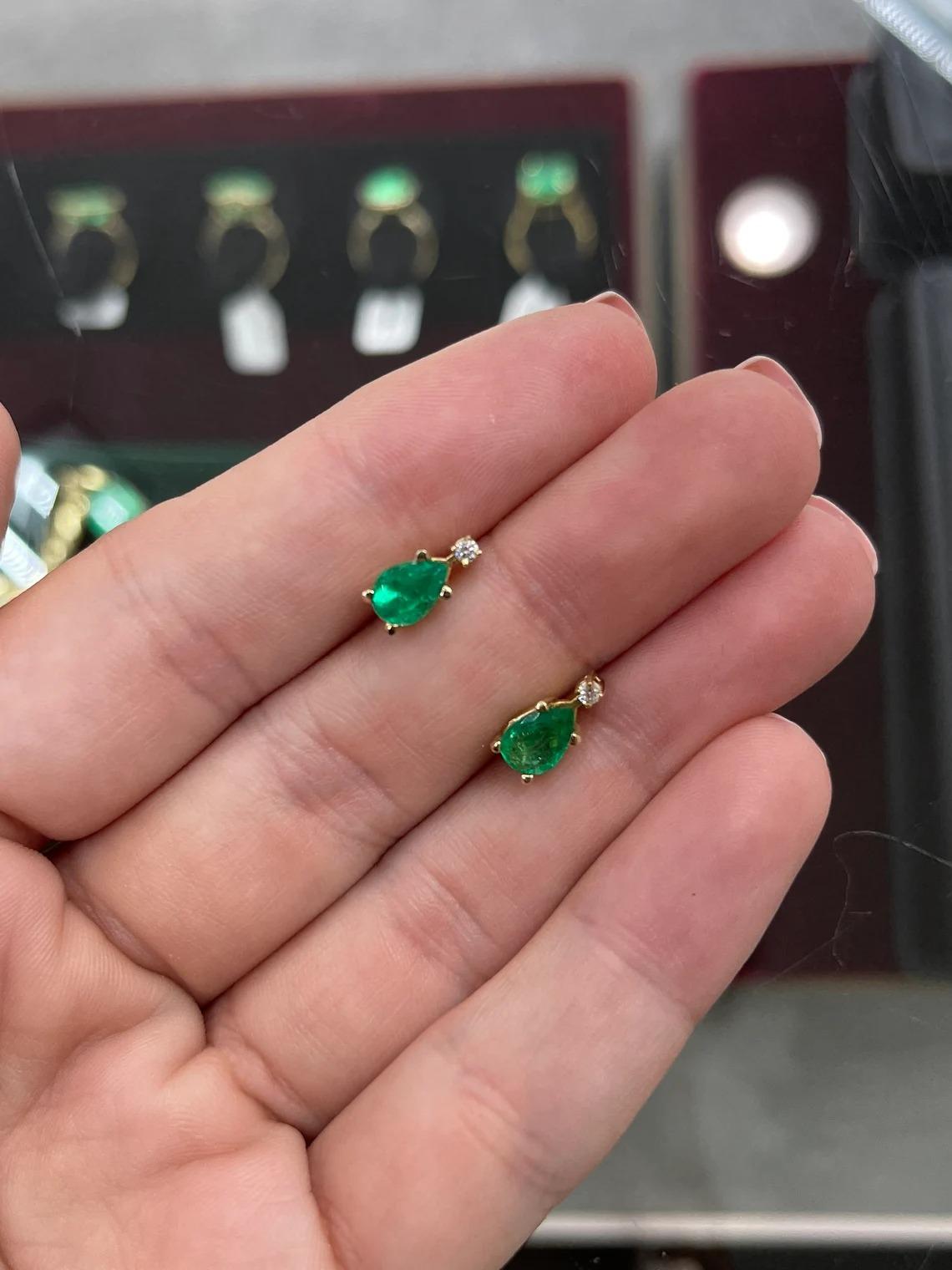 Elegance defined! These teardrop emerald and diamond earrings are fashioned in solid 14k yellow gold. These studs feature genuine Colombian emeralds accented with natural white diamonds. The emeralds have a combined 1.38 total carat weight and a