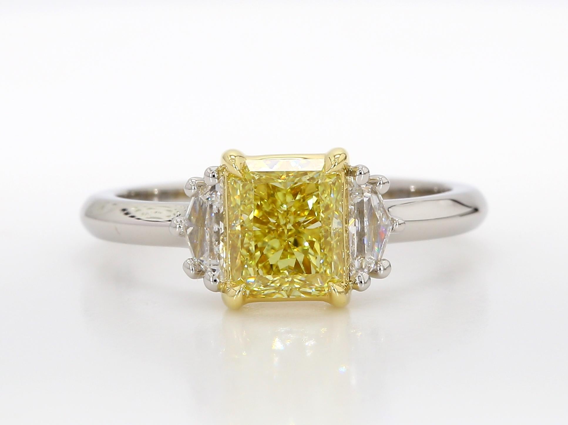 Cette magnifique bague de fiançailles à trois pierres est ornée d'un diamant radiant de 1,42 carat de couleur jaune intense. Ce diamant a été certifié par la GIA comme étant sans défaut interne, ce qui souligne sa clarté exceptionnelle. Le diamant