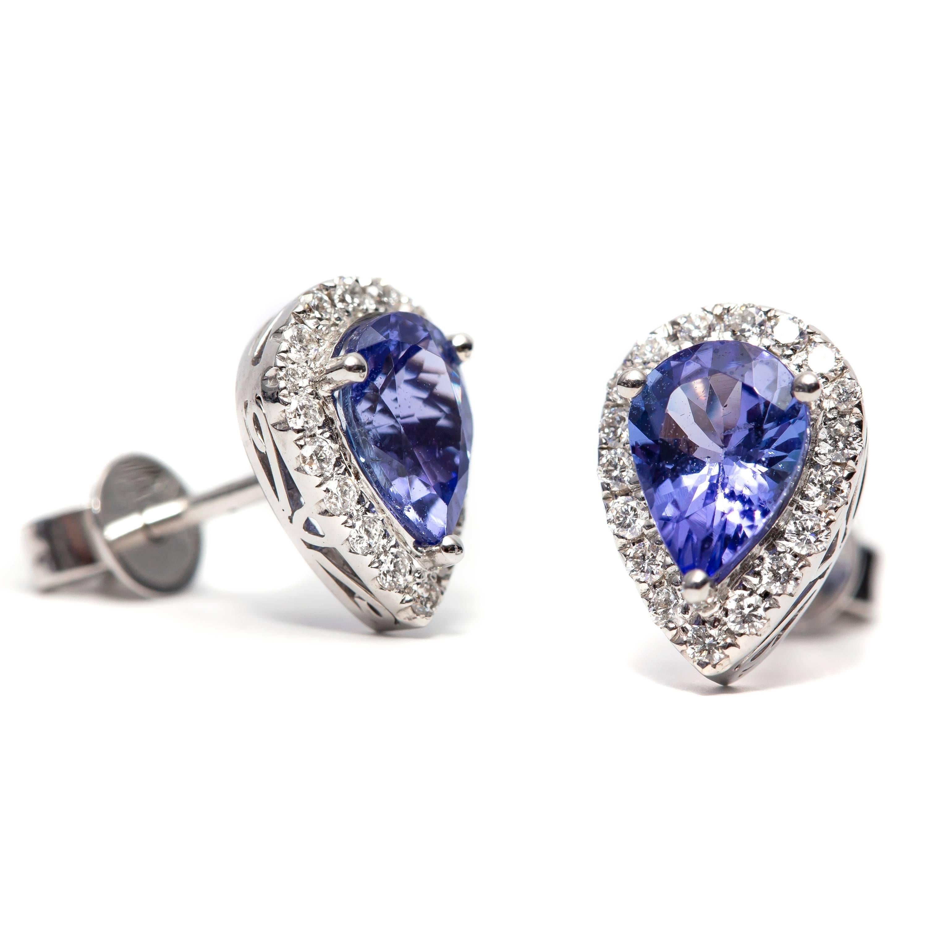 A beautiful pair of 1.42 Carat pear shaped tanzanite earrings featuring 0.30 Carats of color G clarity VS1 round White brilliant diamonds. Set in 18 Karat White Gold. These earrings are available in other carat sizes. As well as 18 Karat Yellow and
