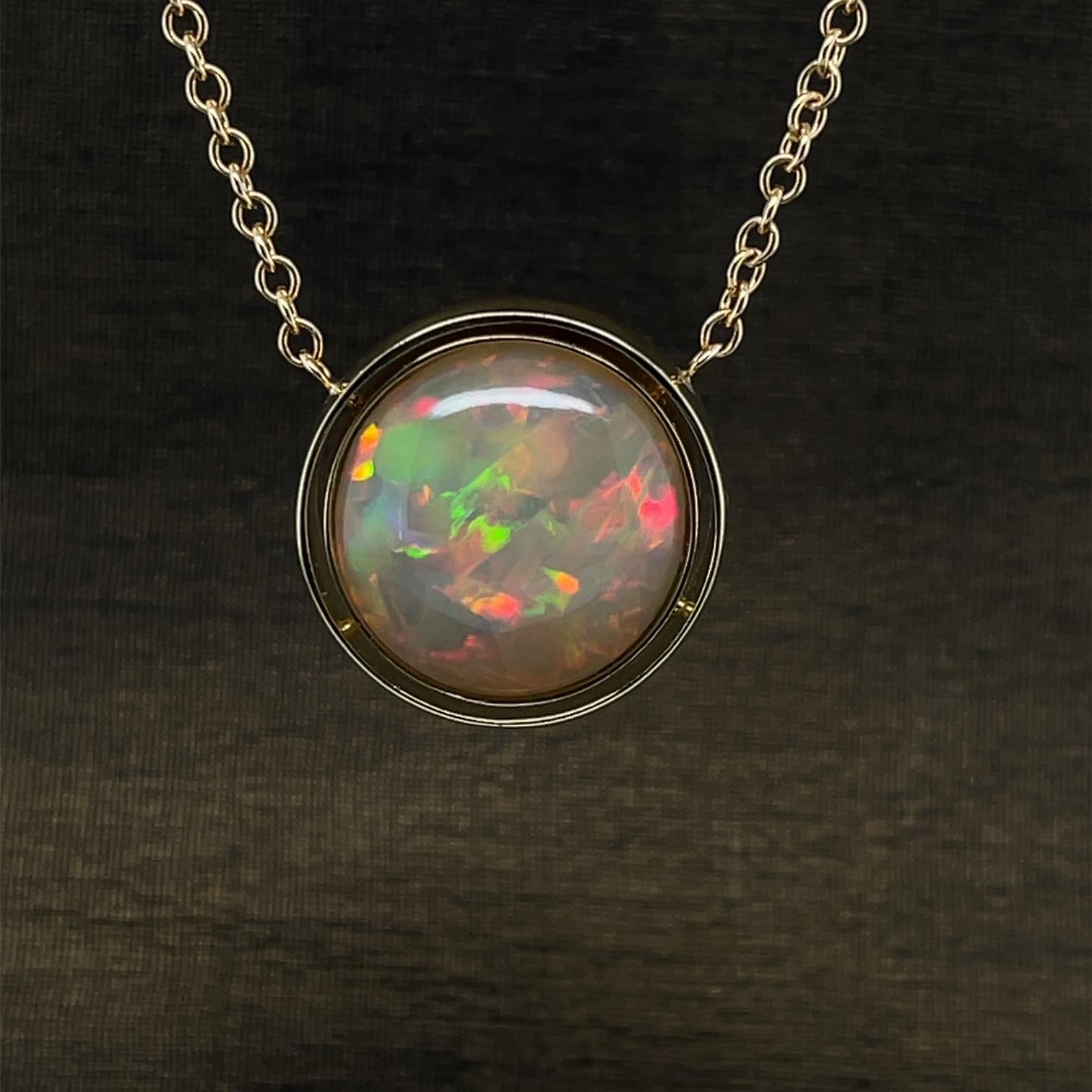 Beautiful and bright! This pendant features a large and impressive golden Ethiopian opal set in an 18k yellow gold handmade bezel. Opals are truly the rainbow of all the gemstones with their prismatic play-of-color or 