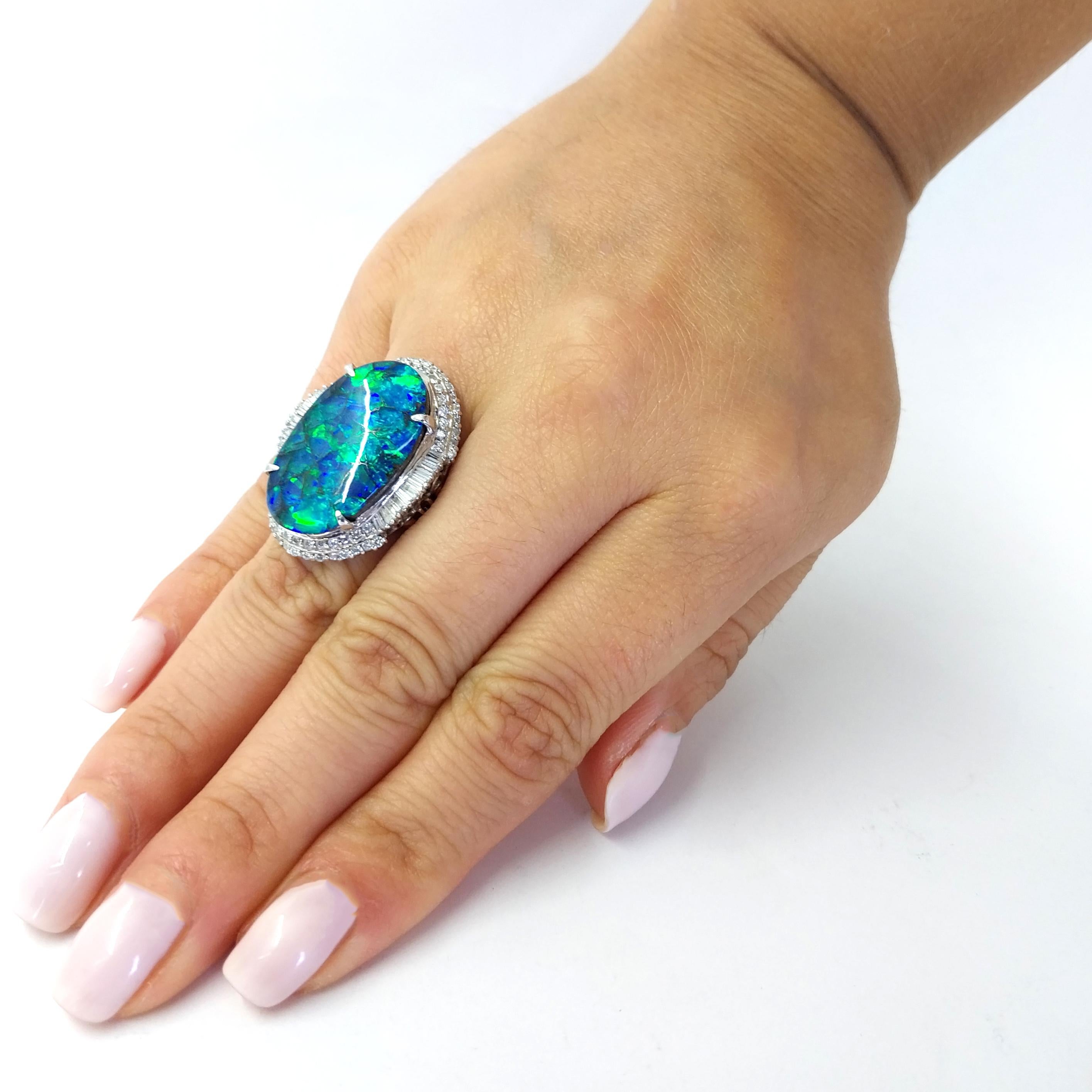 Platinum Ballerina Ring Featuring A 14.22 Carat Oval Boulder Opal with Stunning Blue and Green Pattern. Accented by 0.90 Carat Total Weight Round and Baguette Cut Diamonds of SI Clarity and H Color. Finger Size 4.75. Purchase Includes One Sizing