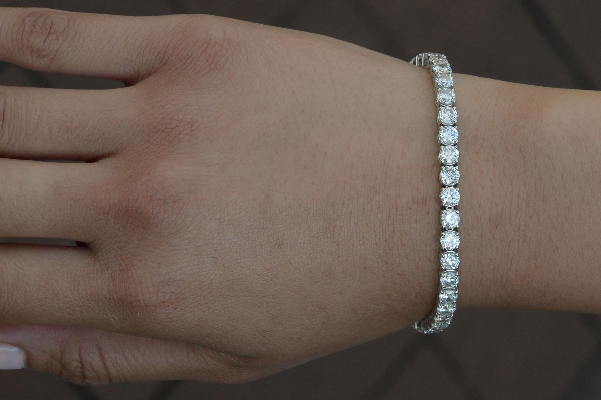 Experience brilliant elegance with this exquisite diamond tennis bracelet. Featuring 14.23 carats total of shimmering, near colorless diamonds (H-I, SI Clarity) set in 14-karat white gold, this straight-line bracelet is the perfect choice for any