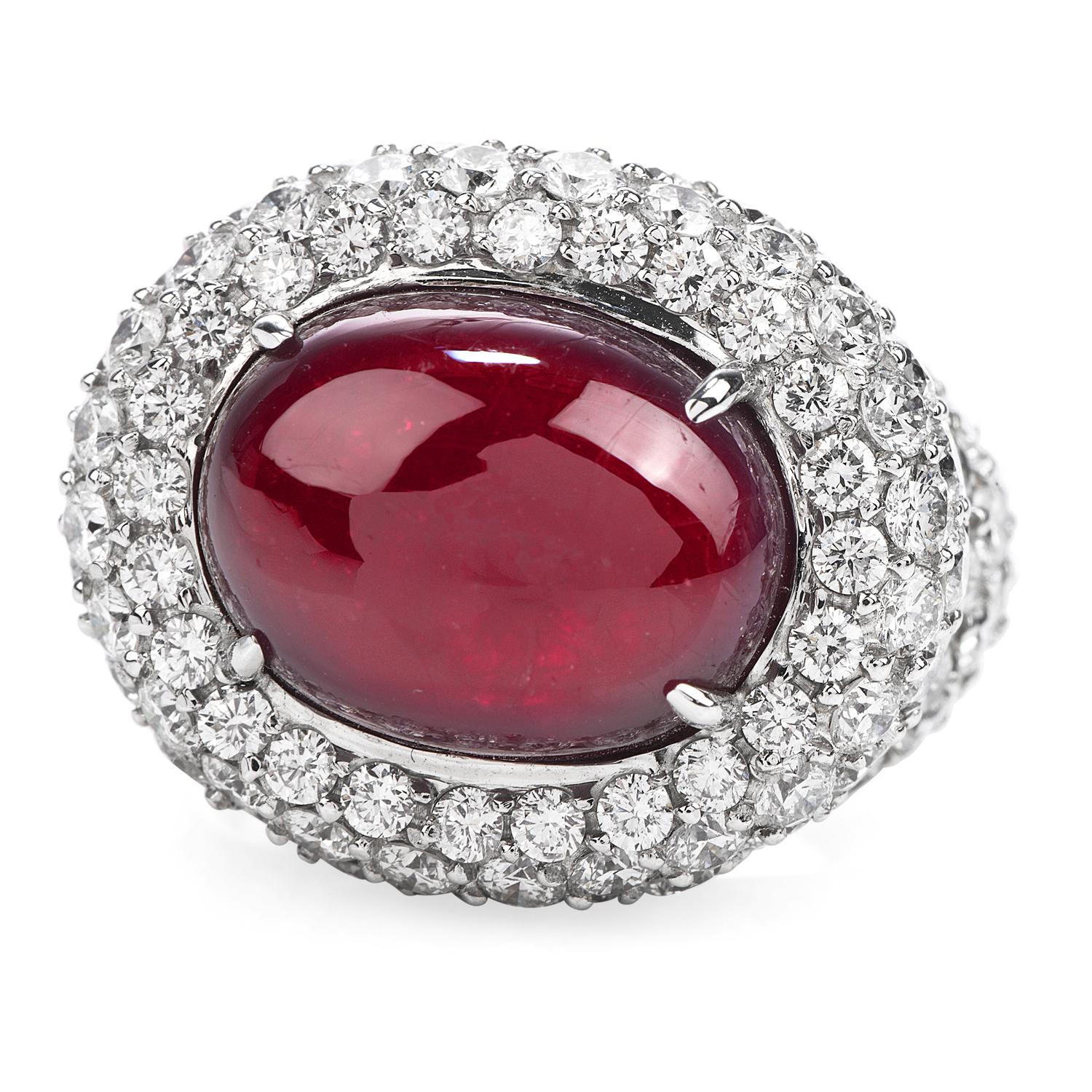 Sumptuous Deep Red Ruby in a Diamond Bed!  This Profound Colored Halo Design Cocktail Ring has a center 14.26 ct Oval Cabochon Ruby, prong set, It is crafted in solid 18K White Gold, and it is adorned by a Cluster Pave Style Round Cut Diamonds, with