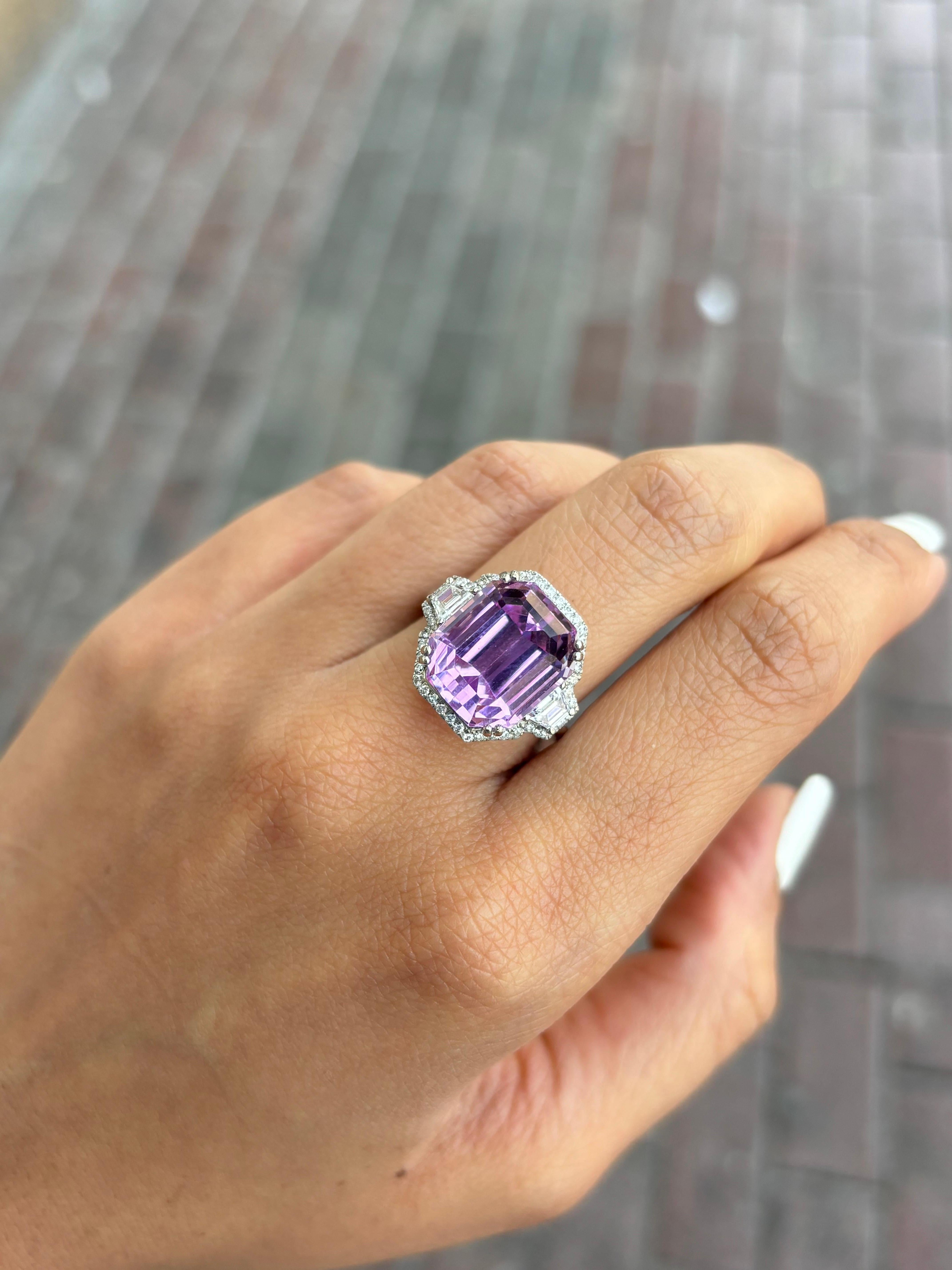 A stunning purple-pink 14.27 carat emerald cut Kunzite center stone, with 0.37 carat trapeze shaped White Diamond side stones, VS quality G/H color, and 0.32 carat round White Diamonds surrounding it. The Kunzite is of top quality, ideal intense