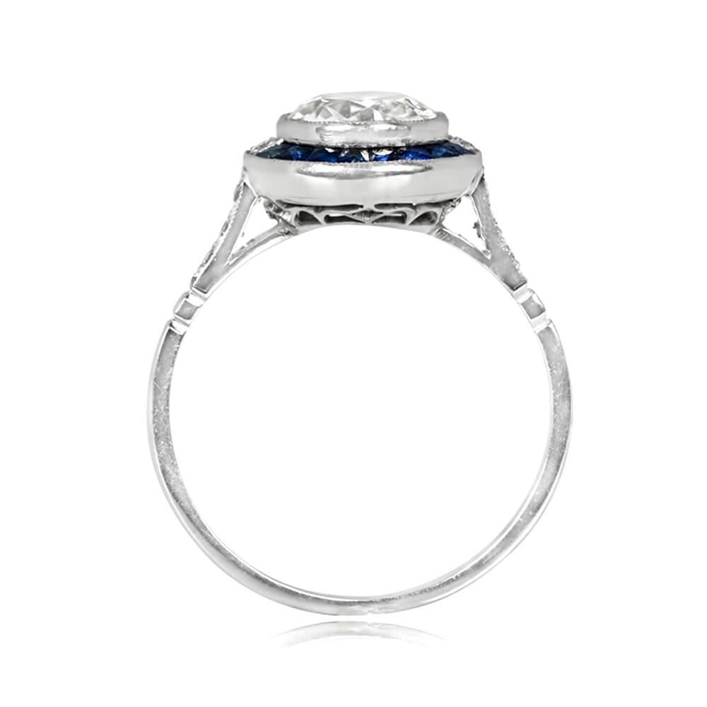 This halo engagement ring boasts a stunning 1.42 carat old European cut diamond, K color and SI1 clarity, bezel-set and surrounded by a beautiful halo of calibre French-cut natural sapphires weighing 0.48 carats in total. The shoulders of the ring