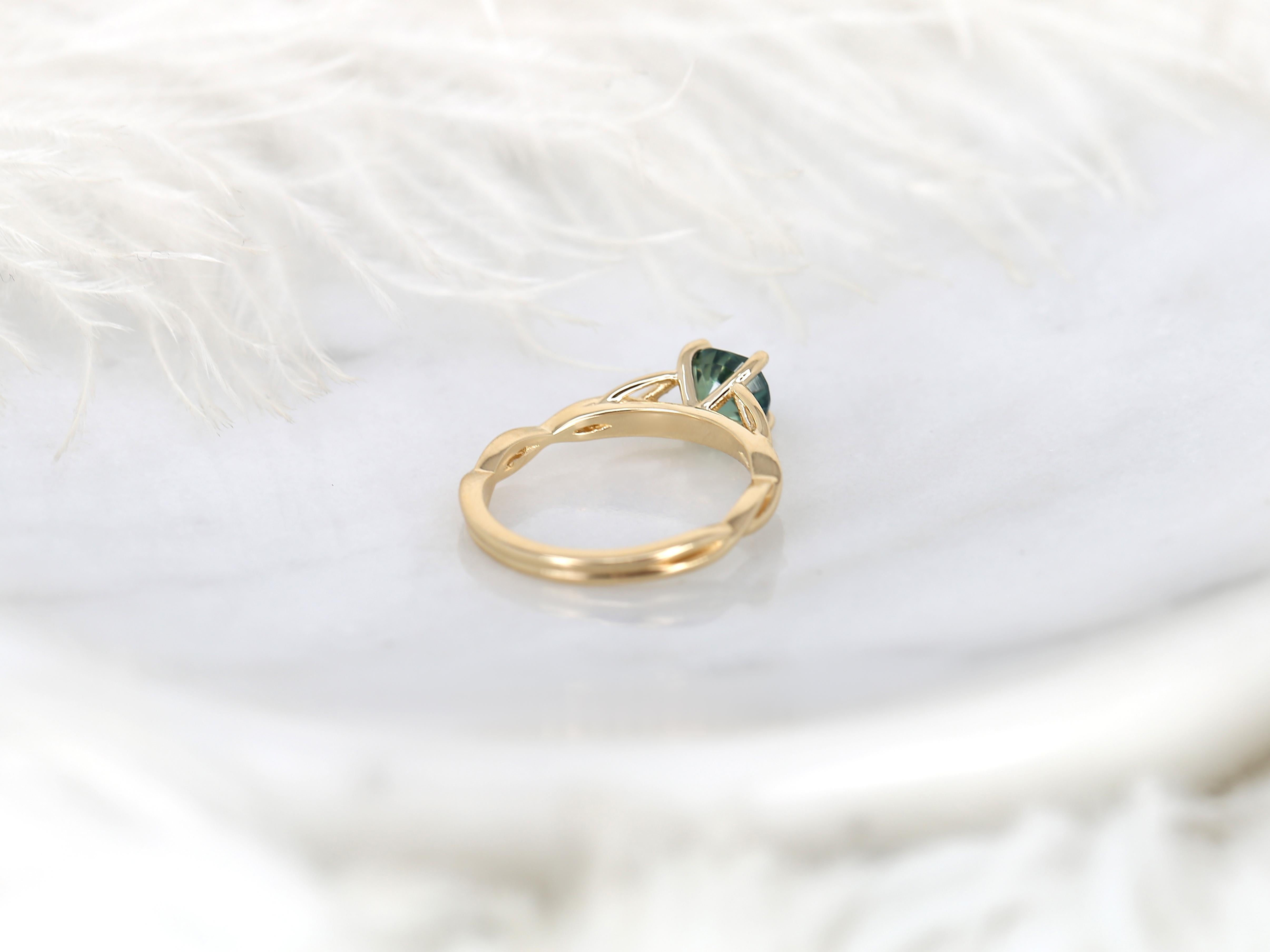 This exquisite 1.42ct Petite Cassidy 14kt Teal Sapphire Celtic Love Knot Round Solitaire Ring, Crossover Ring, and Triquetra Ring makes a stunning statement, exuding an air of sophistication and luxury.

Detail of Ring(s)

Center Stone