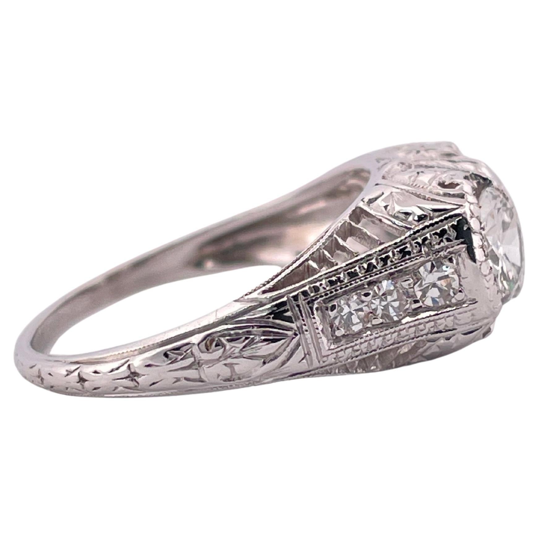 Dieser exquisite Platinring im Vintage-Stil besticht durch seine zeitlose Eleganz und die filigranen Details, die von Hand eingraviert wurden. Das 3,8 Gramm schwere, aus luxuriösem Platin gefertigte Schmuckstück besticht durch ein Duo von Diamanten