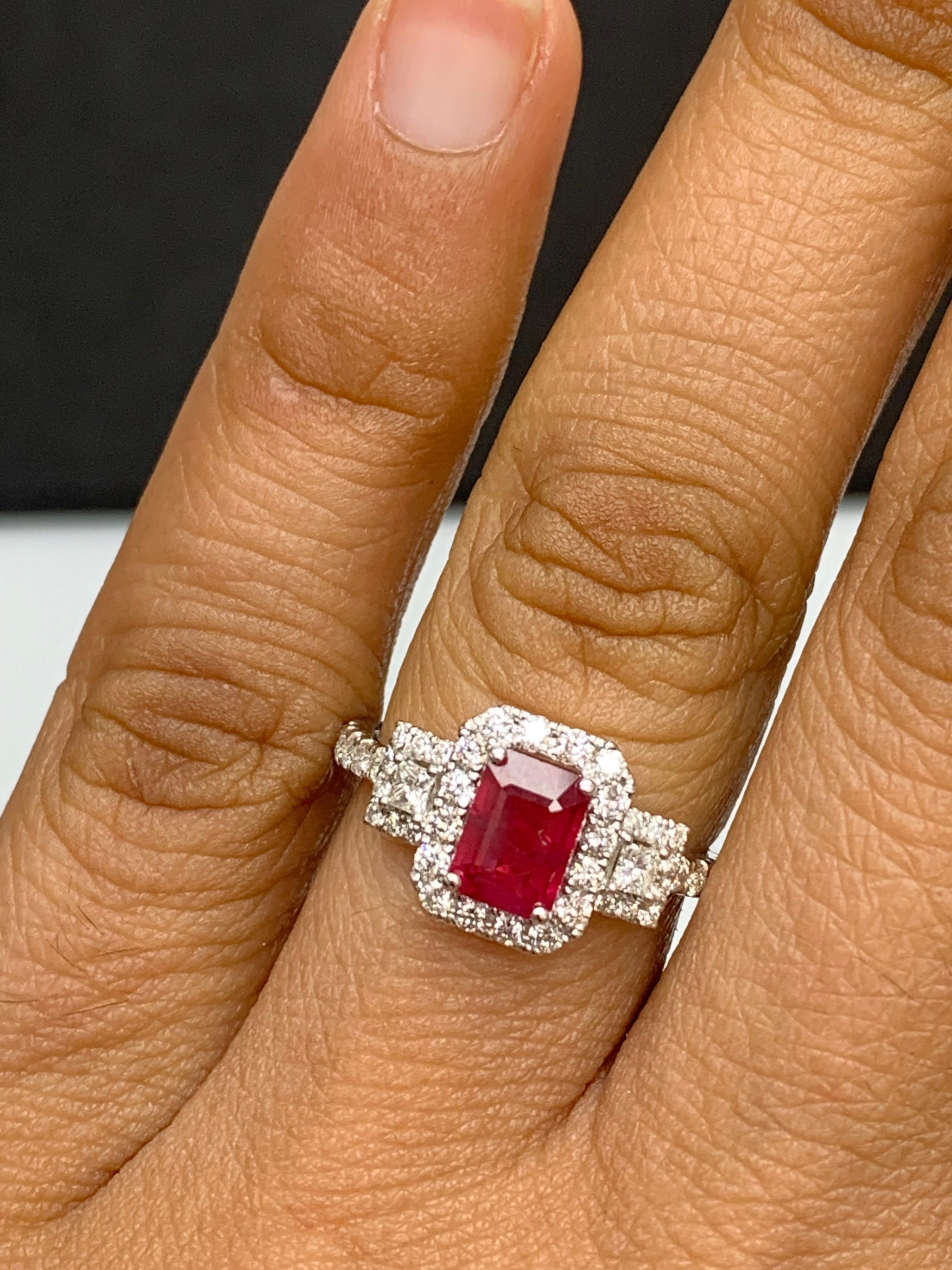 A stunning ring showcasing a rich red emerald cut Ruby weighing 1.43 carats surrounded by diamonds. The center stone is surrounded by a row of 42 diamonds, weighing 0.57 carats total, with 2 princesses cut diamonds on each side. Made in 18K White