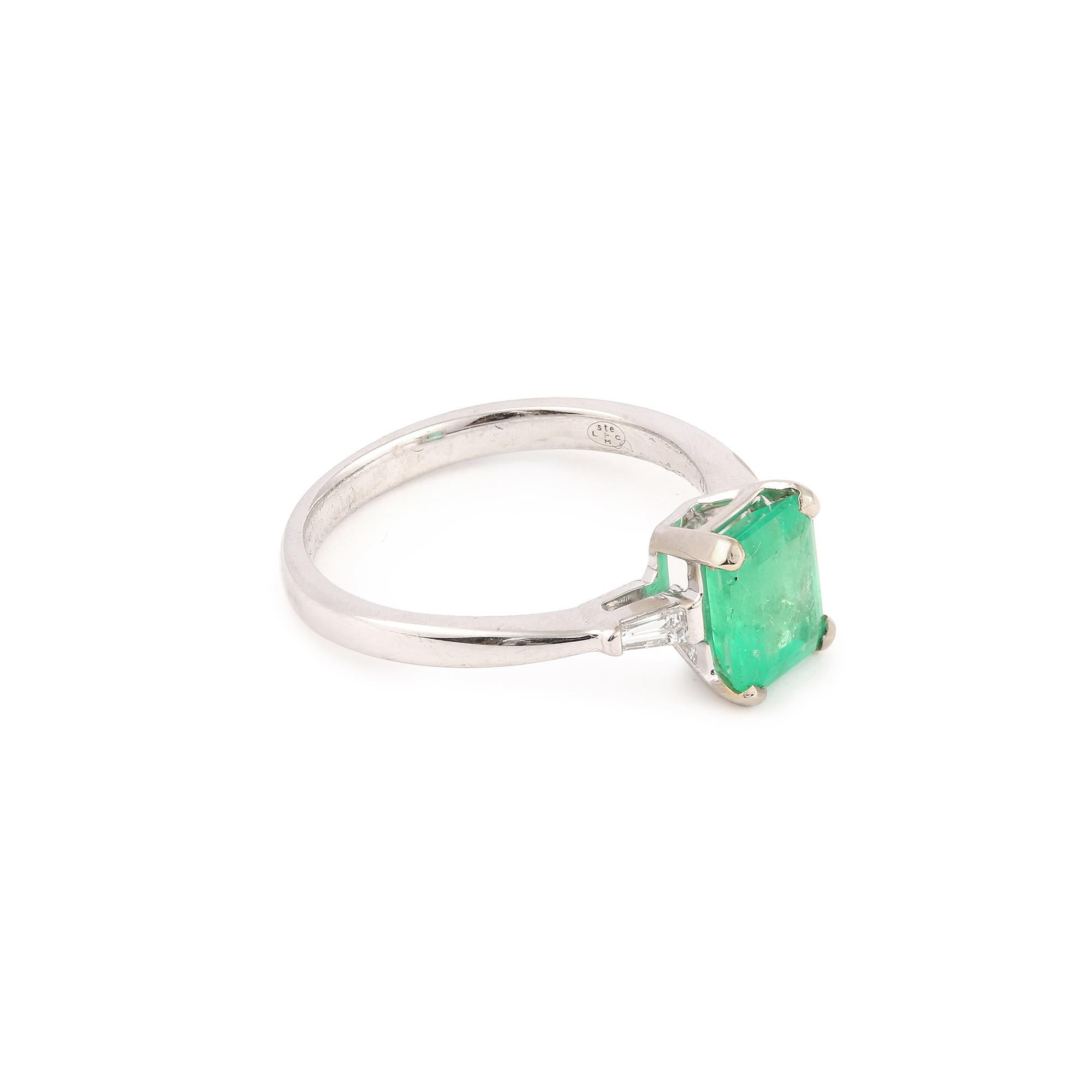 Ring aus Weißgold, besetzt mit einem kolumbianischen Smaragd im Smaragdschliff, der auf beiden Seiten mit kleinen trapezförmigen Diamanten besetzt ist.

Geschätztes Gewicht des Smaragds: 1,43 Karat

Geschätztes Gesamtgewicht der Diamanten: 0,10