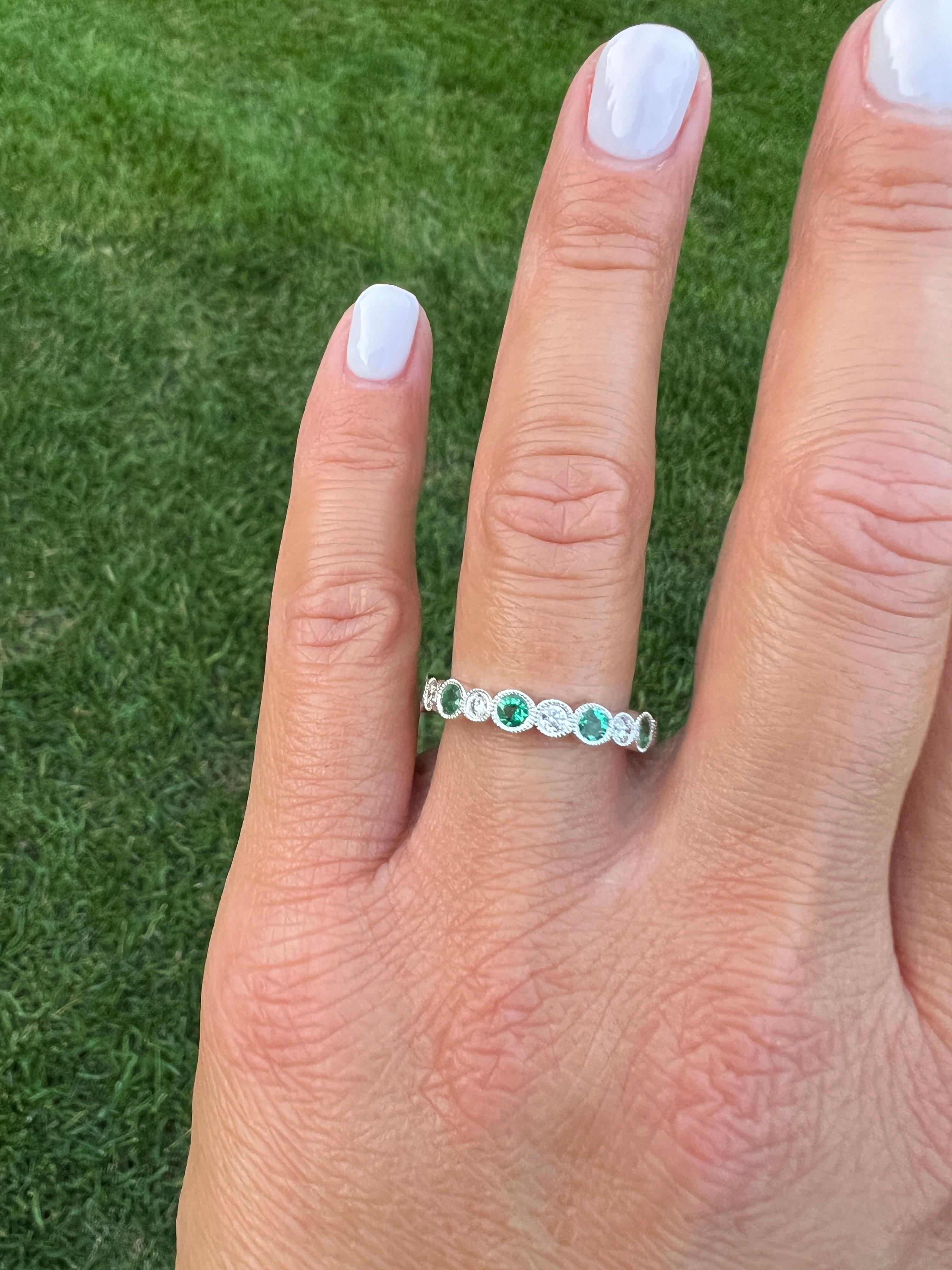 Looking for a stunning piece of jewelry to make a statement? Look no further with this round emerald and round diamond eternity ring. With its classic design and timeless beauty, this ring is the perfect way to add a touch of elegance to any outfit.