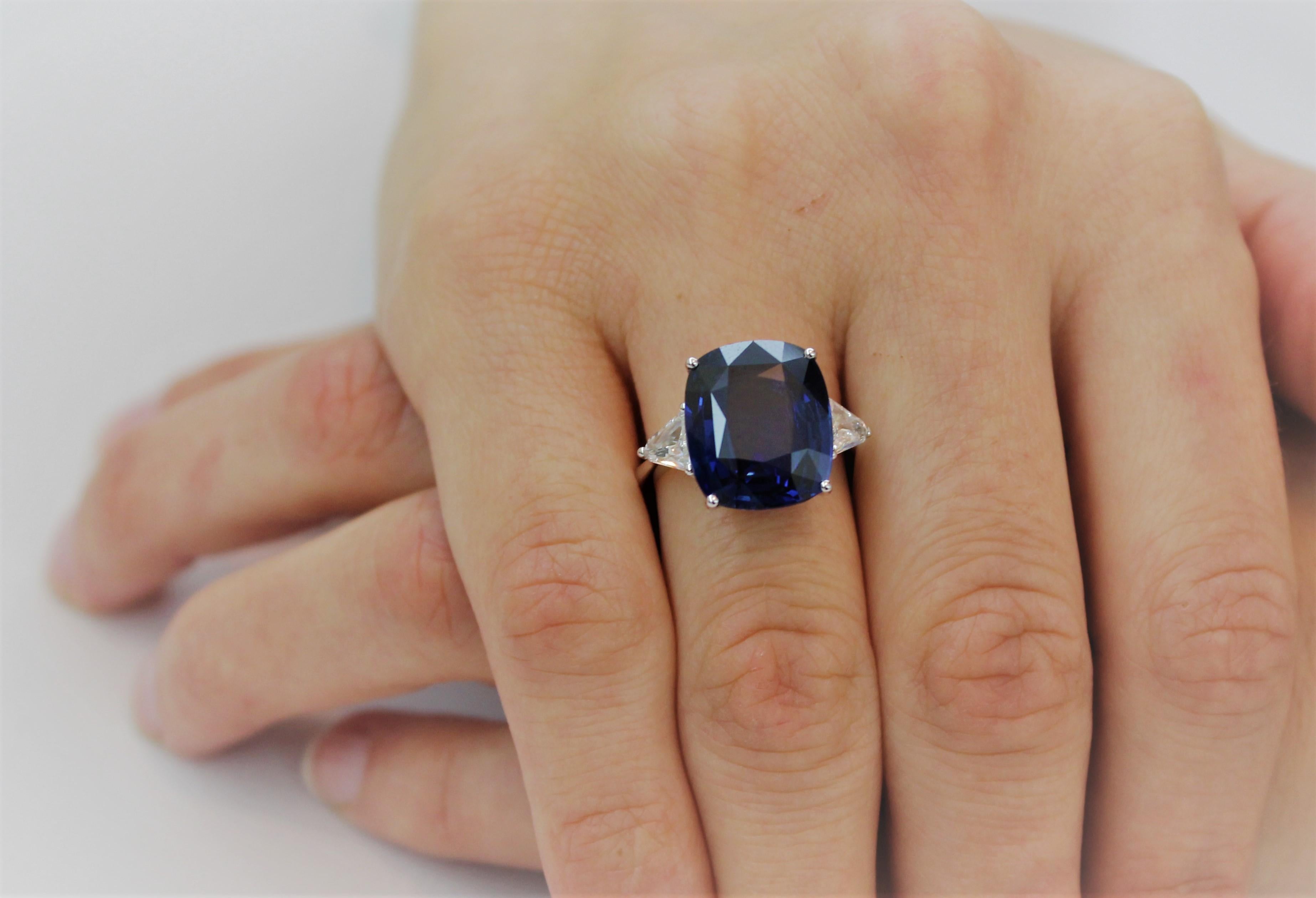 Entirely Hand-Made in Italy 14.30 Carat Cushion Blue Sapphire Engagement Ring.
The Vibrant Blue of the Sapphire is enhanced by 2 White Trillon Diamonds of 0.74 Carat total on the side.
