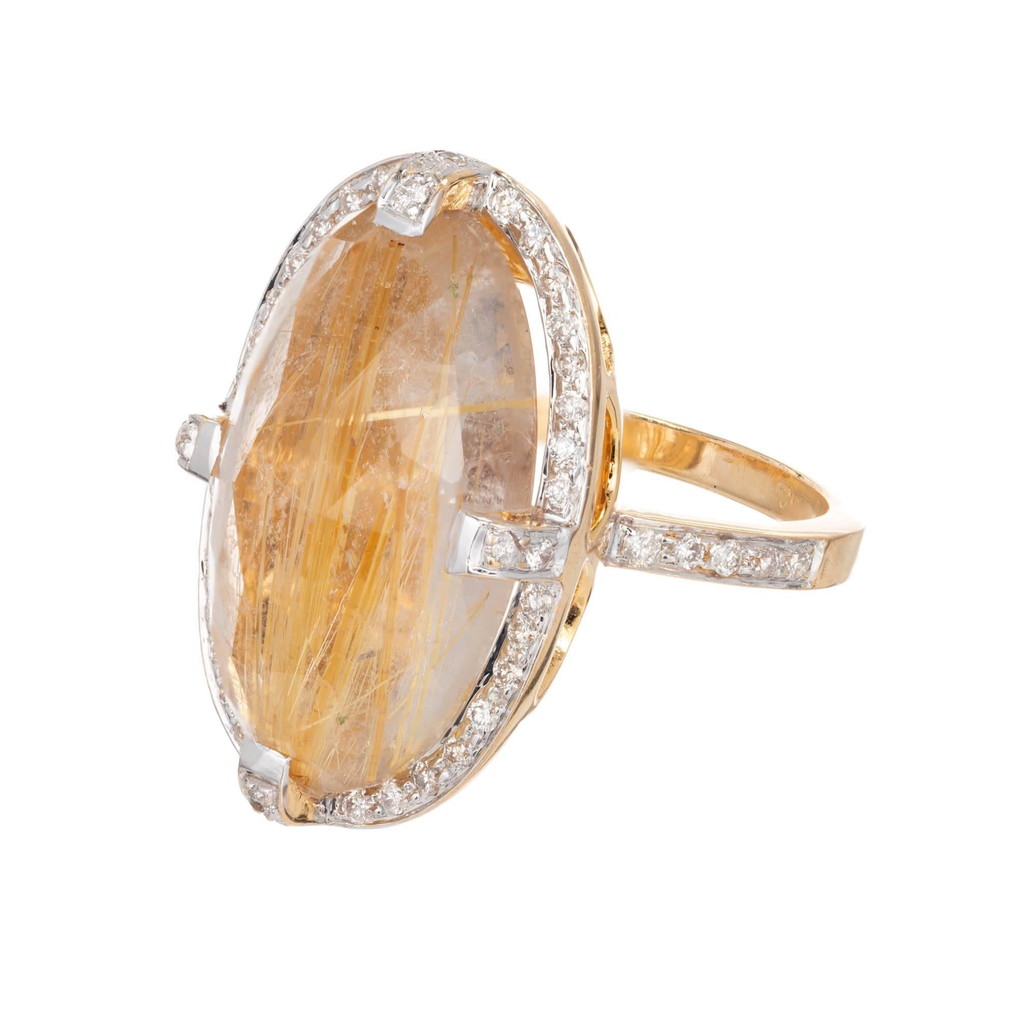 Rutilated quarts and diamond cocktail ring. Large oval faceted cabochon of rutilated quartz is set with diamond studded prongs and is surrounded by a diamond halo on top of a decorative and undercarriage. 14 white and yellow gold. 

1 oval faceted